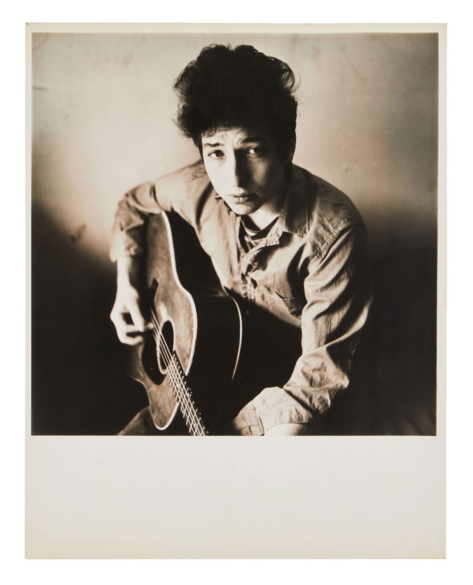 Bob Dylan | Large Vintage Photograph From Don Hunstein's 1963 Session: A vintage 1960s photograph on archival paper of Bob Dylan in his New York City apartment on West 4th Street. Pencil notations on verso of image with a series of numbers and letters likely film roll an