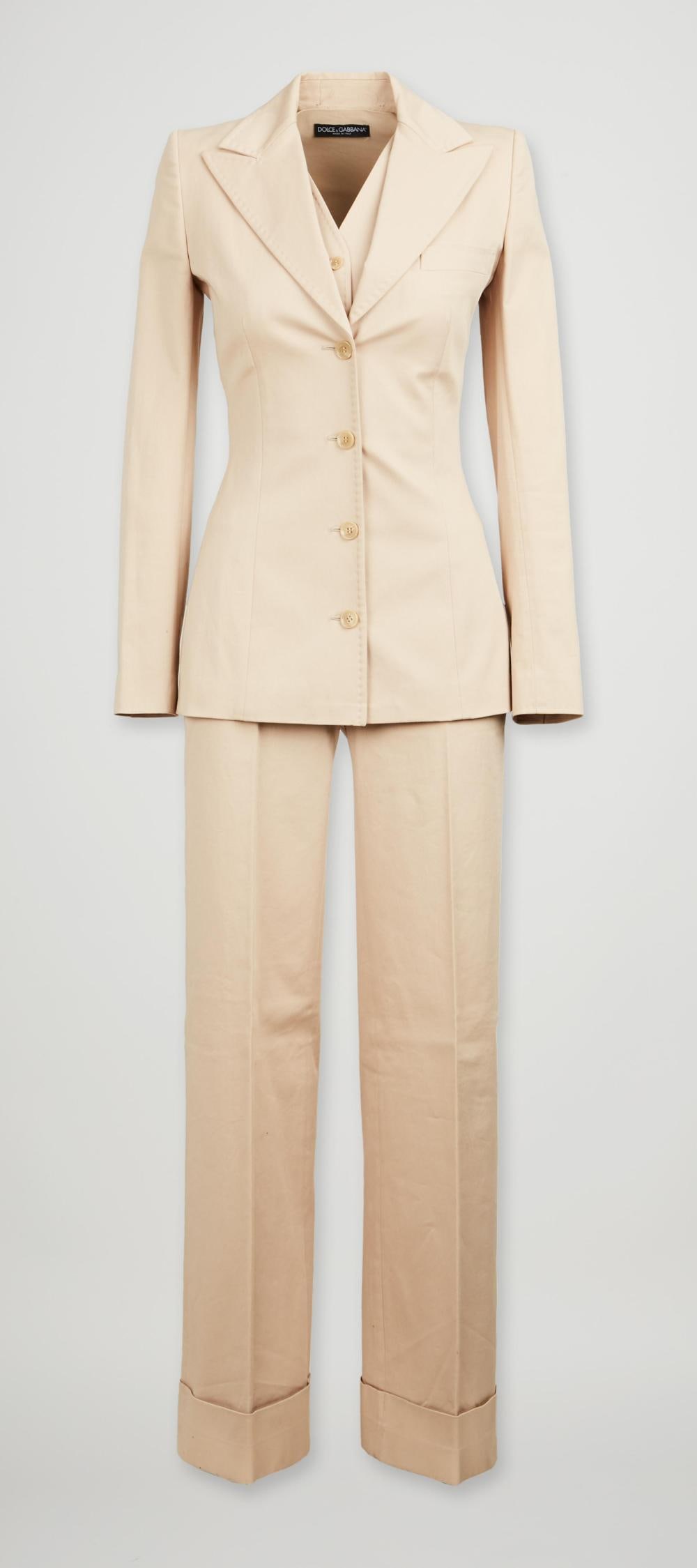 Dolce and Gabbana | Spring 2002 Beige Three Piece Suit: Dolce and Gabbana beige three-piece suit designed for the spring/summer 2002 ready-to-wear collection. The suit features a top-stitched, wide peak lapel, a single-breasted blazer with fitted tailoring