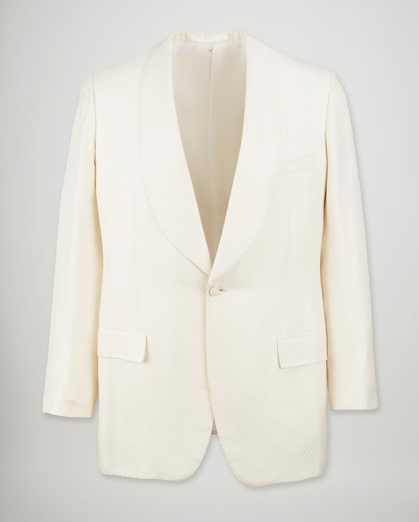 Jack Taylor | 2004 White Jacquard Dinner Jacket: Here we have a white silk jacquard dinner jacket by Jack Taylor impeccaby tailored with his signature single button closure. It has a wide shawl collar lapel with a single welted pocket at right breas