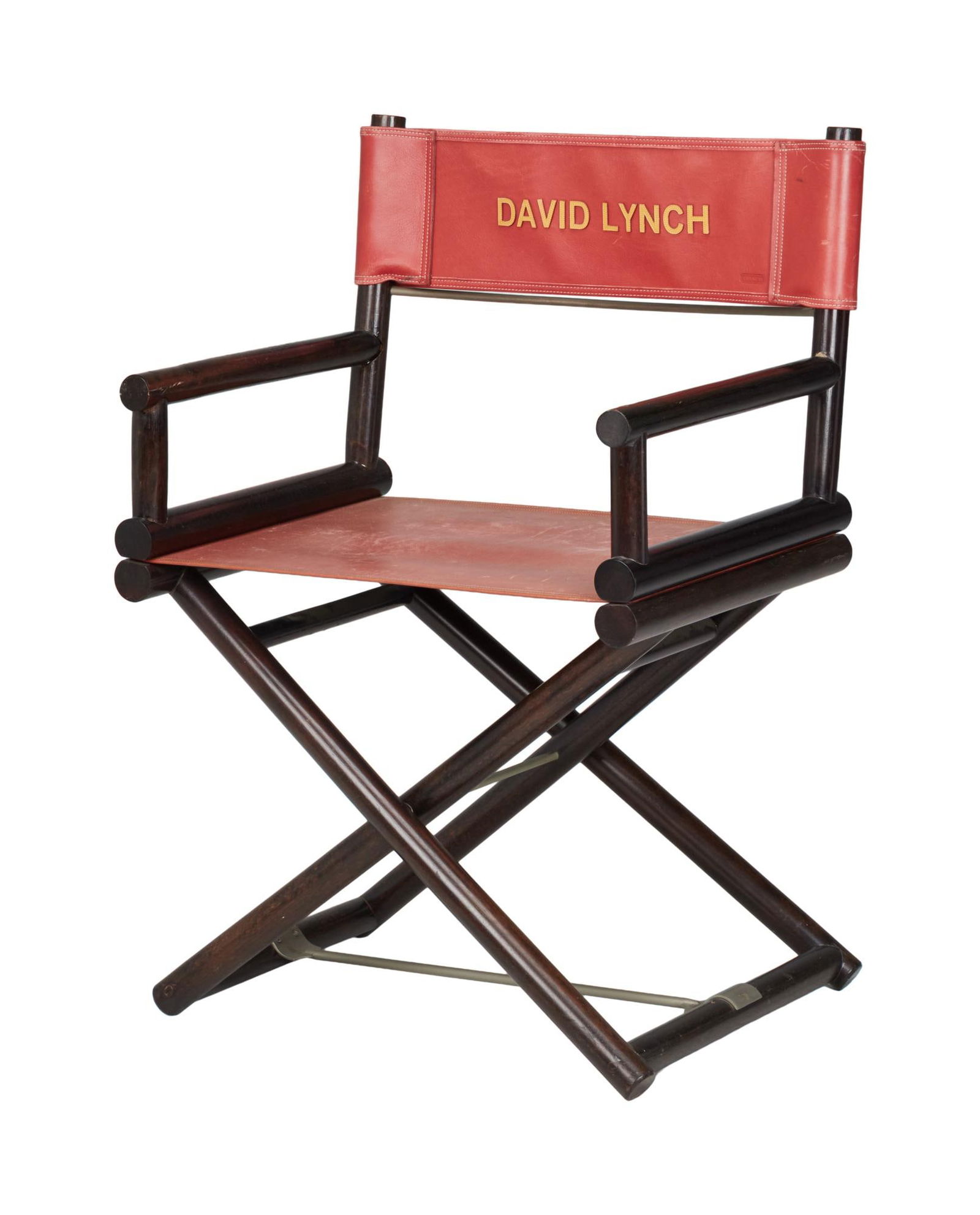 David Lynch | Personalized Director's Chair: A director's chair personalized for filmmaker David Lynch. Comprised of a varnished wooden frame with red leather seat and chairback. The chairback is emblazoned with the name of the filmmaker in