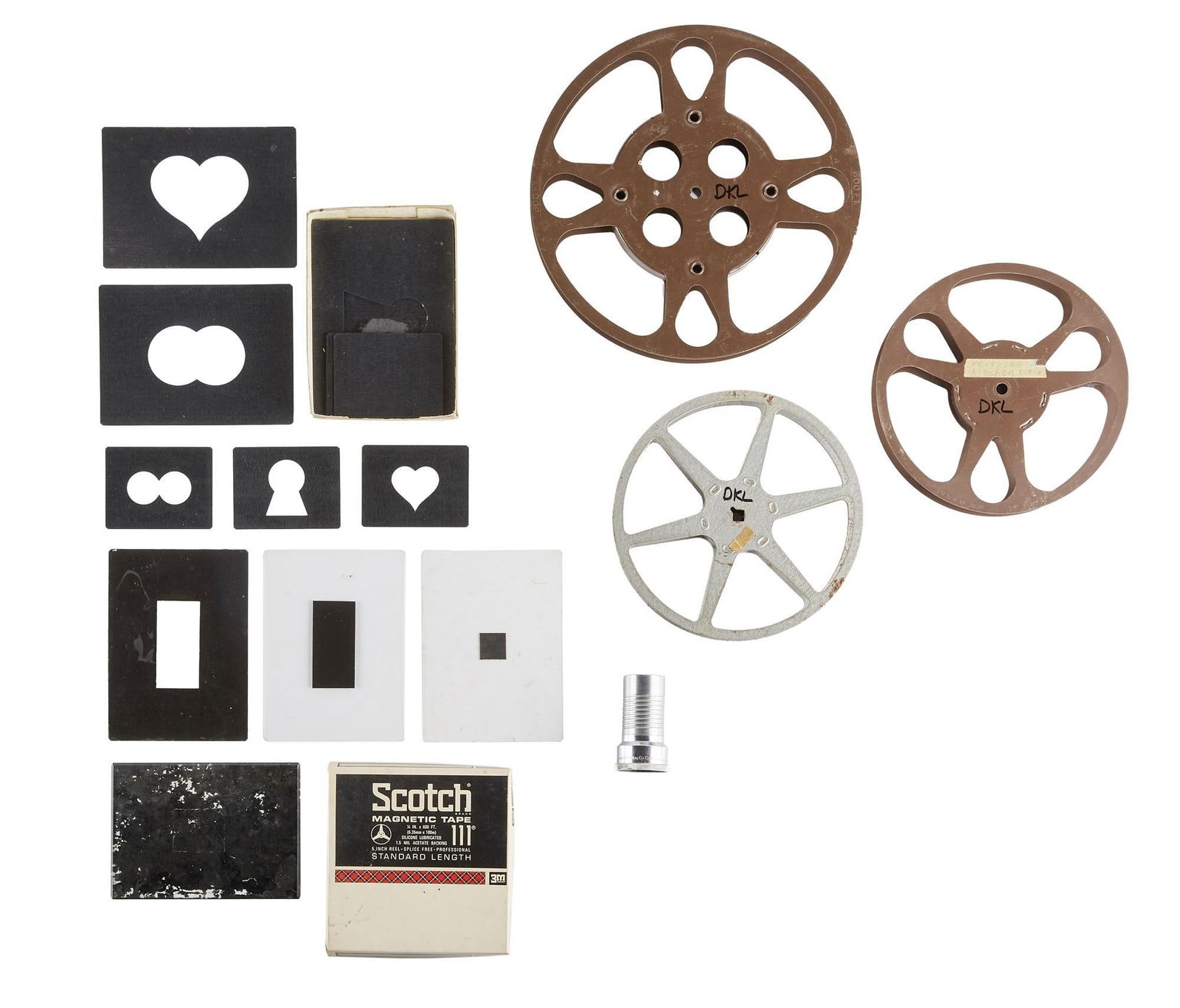 David Lynch | Early Film Tools: Three 16mm film reels, one labeled "Reverse Kitchen Scene," together with a projector lens, an empty reel-to-reel tape box, and a group of alphabet stencils with several hand-painted glass a