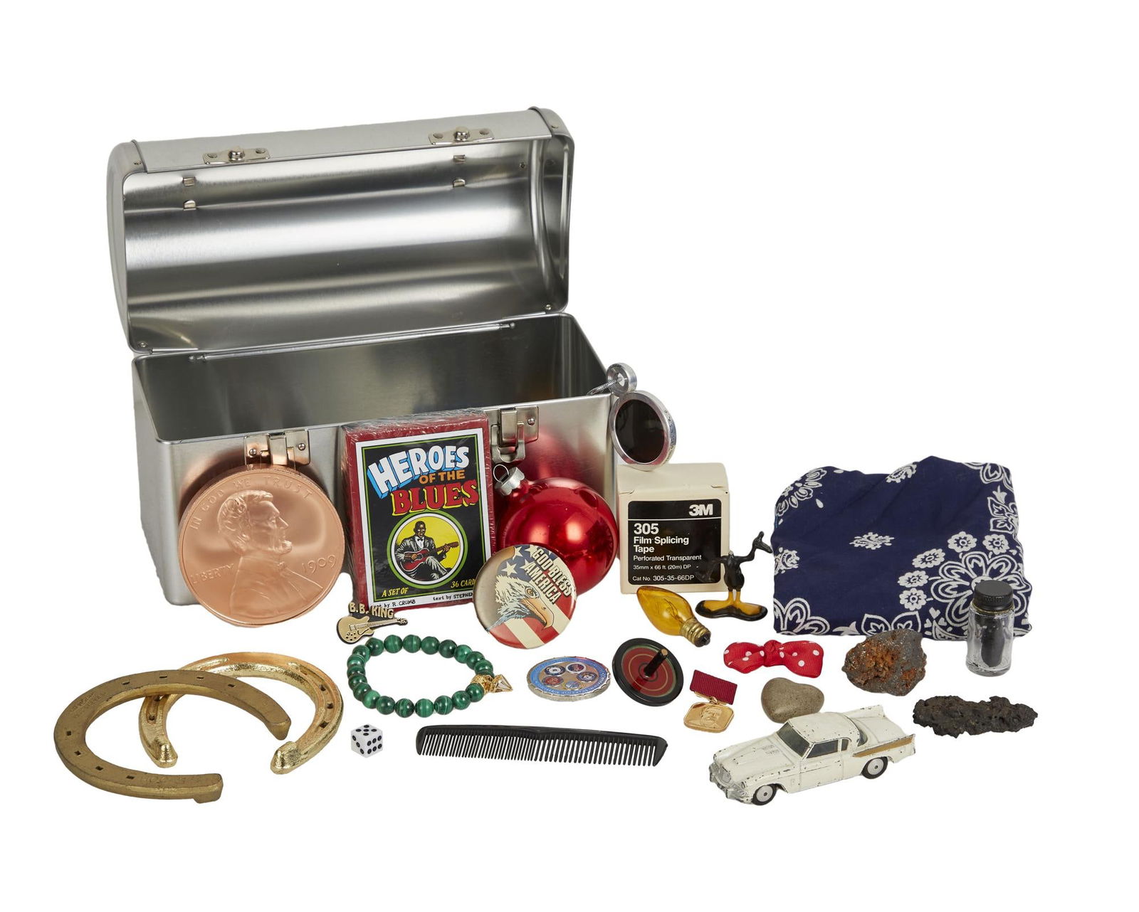 David Lynch | Lunchbox with Trinkets: A metal lunchbox filled with trinkets from David Lynch's home office. The trinkets include an unopened box of "Heroes of the Blues" trading cards featuring artwork by Robert Crumb, two g