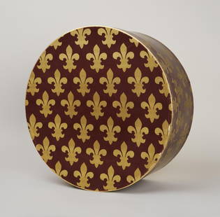Princess Diana | Prince of Wales Patterned Hatbox: A burgundy with gold Prince of Wales pattern hat box belonging to Diana, Princess of Wales. The hat box lid has metallic gold paint along the edge and a gold foil base. Inside the box, there is loose,