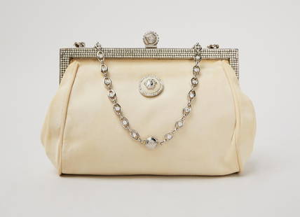 Princess Diana | Versace Off-White Silk Clutch: An off-white silk evening clutch with a silver tone hard with a rhinestone-embellished hinge frame designed by Gianni Versace, belonging to Diana, Princess of Wales. The clutch features two Medu