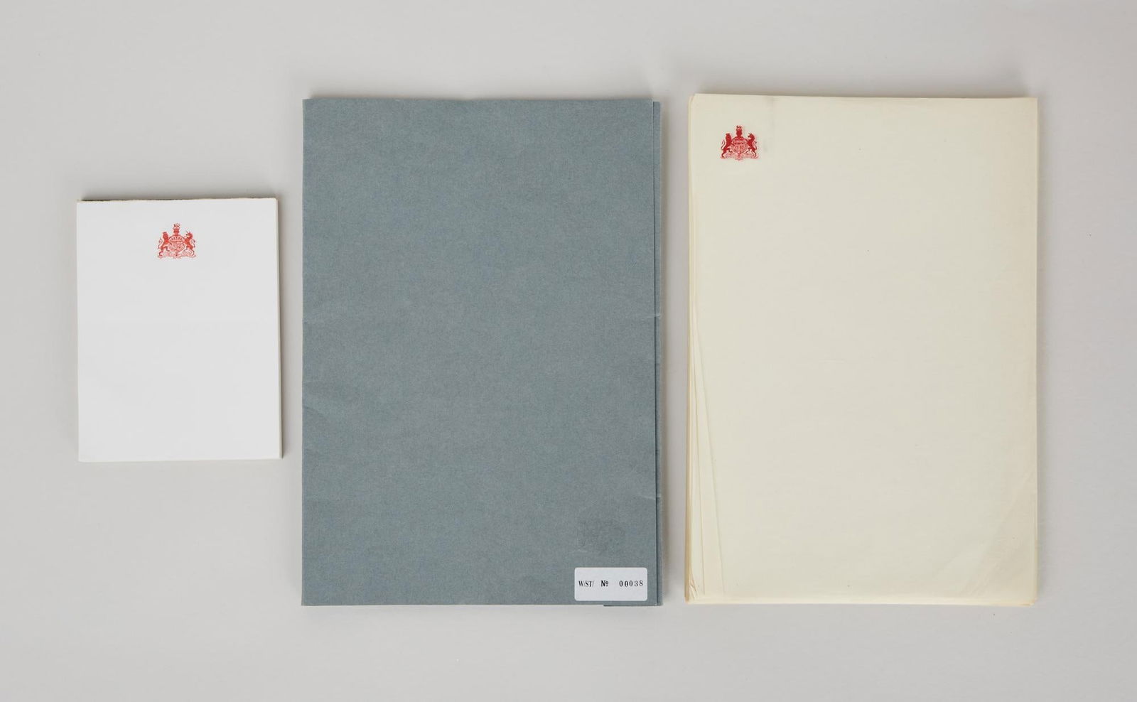 Duke of Windsor | Personal Stationary and Papers: A grey folder with sheets of paper with the United Kingdom Coat of Arms at the top left-hand corner and a pad of white paper with the United Kingdom Coat of Arms at the top center. The stationery belo