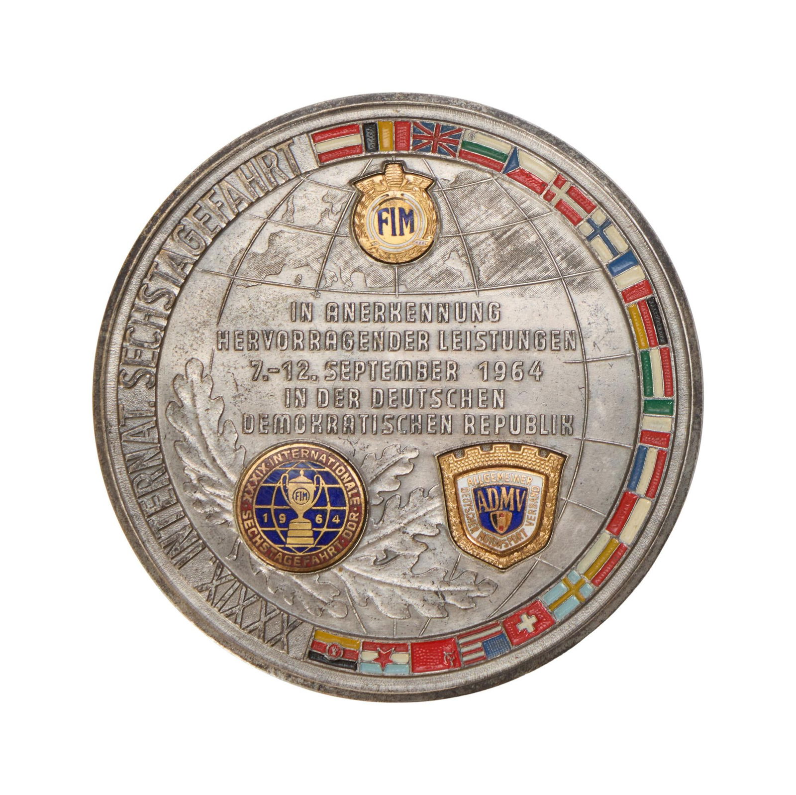 Steve McQueen | 1964 International Six Days Trail (ISDT) Medal: An original 1964 International Six Days Trial recognition medallion issued to Steve McQueen for his participation in the annual motorcycle endurance event, which took place in Eas