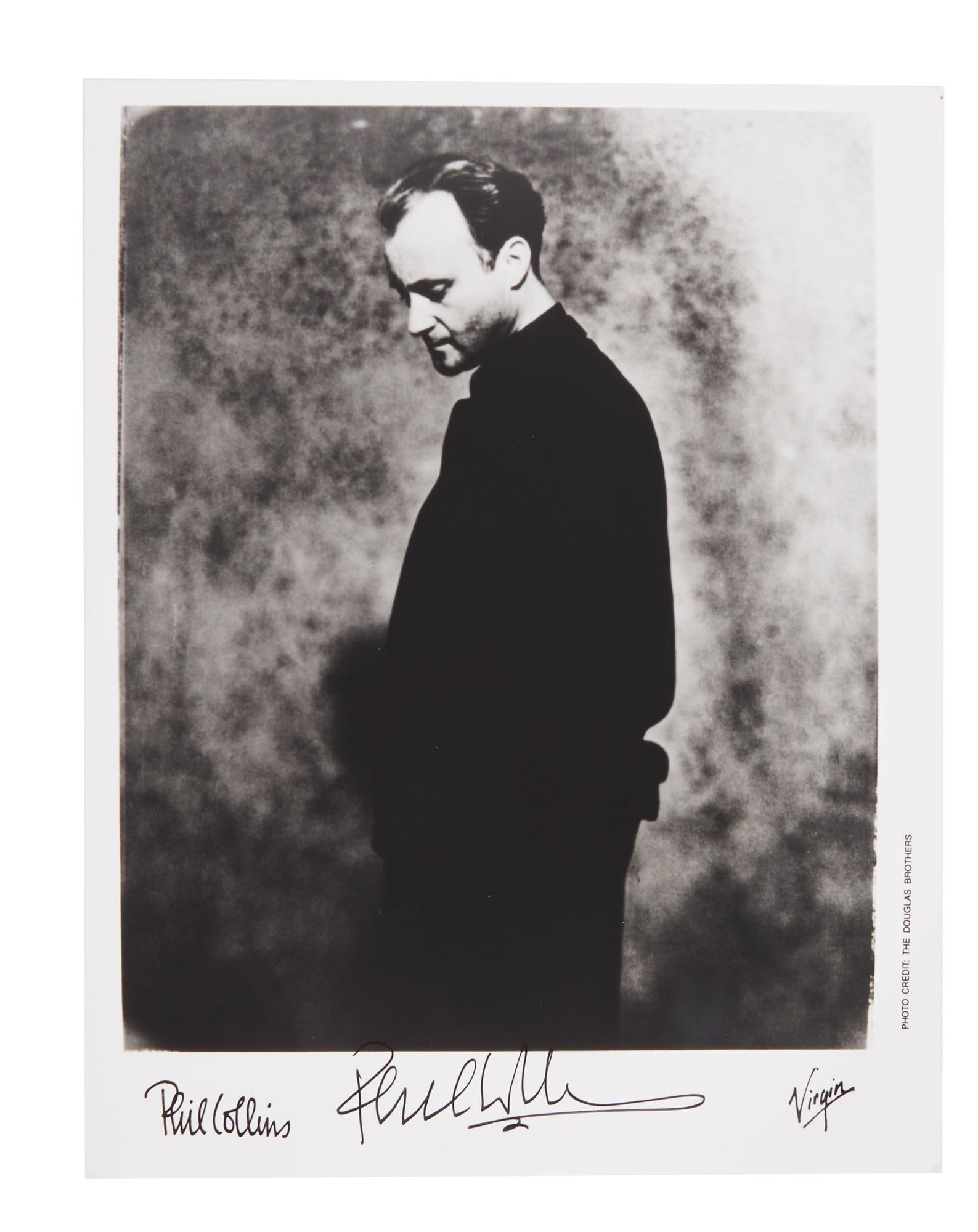Phil Collins | 1980s Virgin Records Promo Photo: A c. 1980s black and white Virgin Records promotional photograph of Phil Collins, signed by Phil in black marker with the word ‘luv’ before his name. 10 x 8 inches