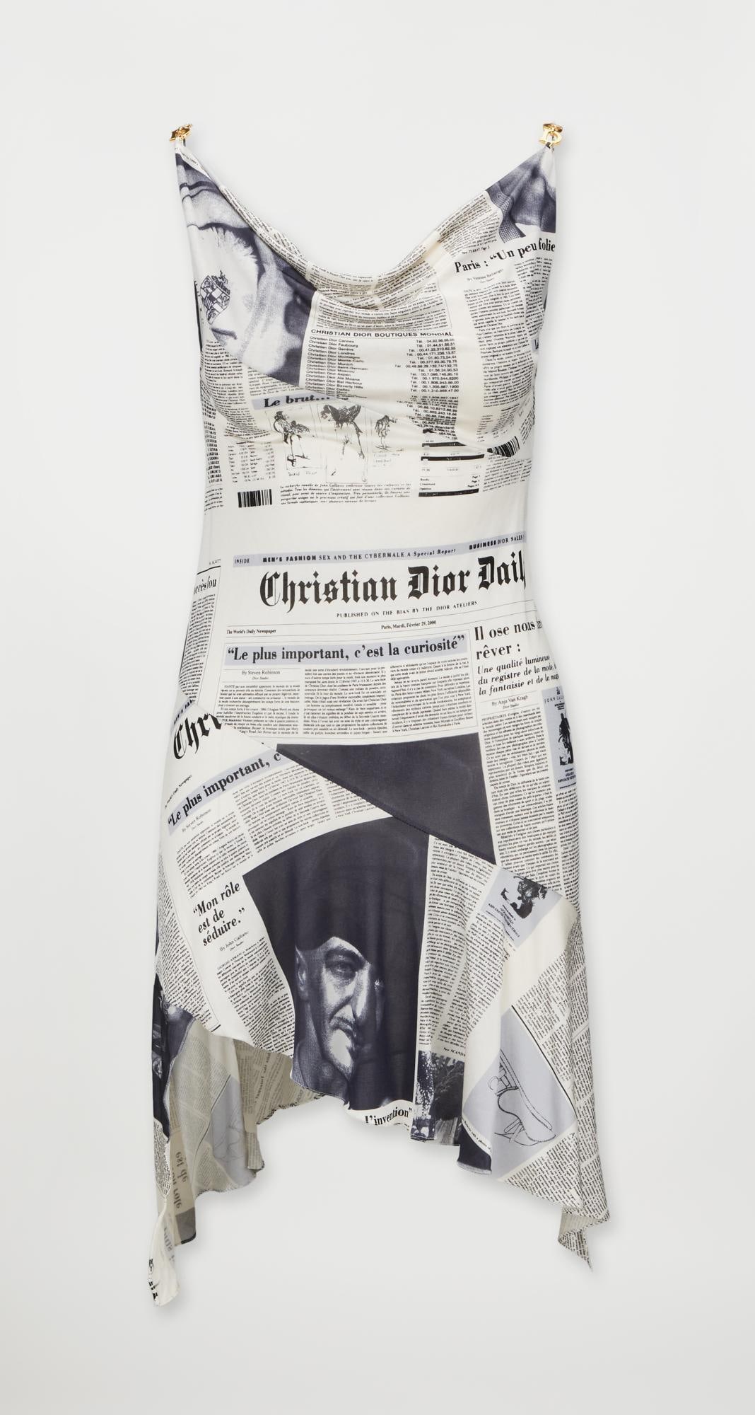 Christian Dior | 2000 John Galliano Dior Gazette Fly Girl Dress: A bias-cut newspaper-print cocktail dress designed by John Galliano for Christian Dior's 2000 fall collection, look 34, the design was seen on model Angie Schmidt on the runway. This iconic