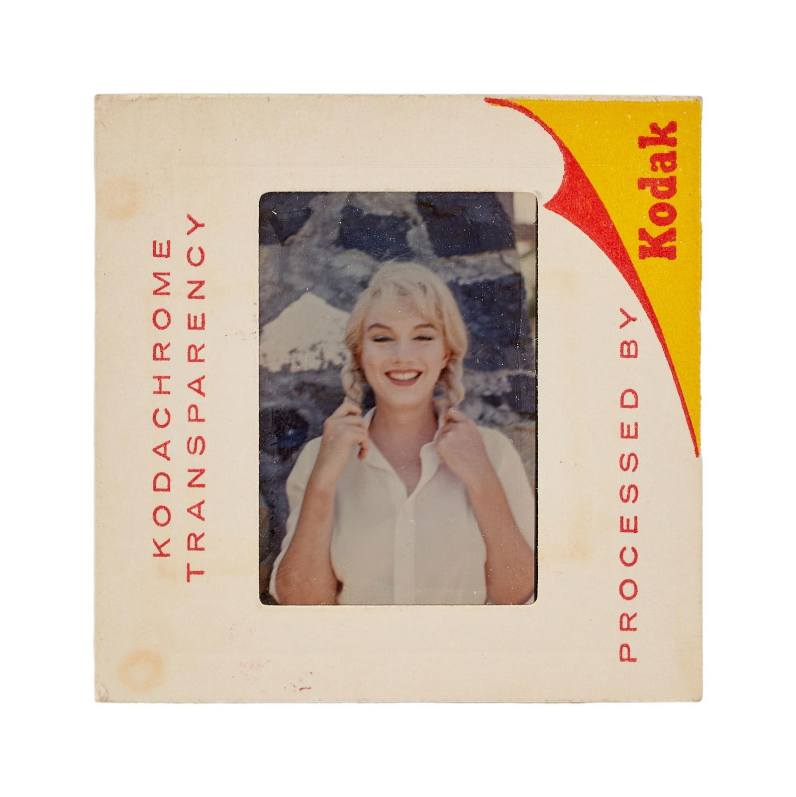Marilyn Monroe | 1960 Rare Color Slide from "The Misfits" by Dennis Stock: United Artists, 1961; of the era, depicting a smiling image of the star on location as she tugs at her braids, housed in its original cardboard "Kodachrome" sleeve; verso with stamped text r