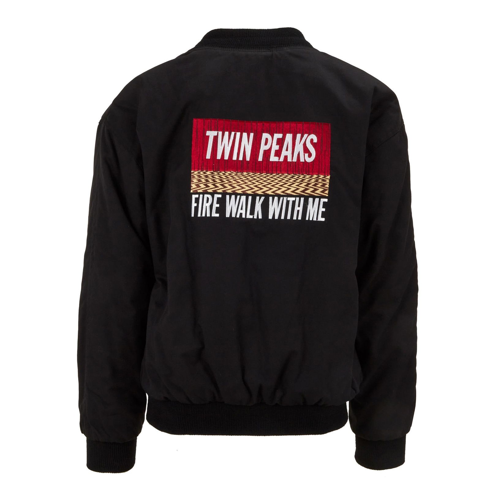 Twin Peaks: Fire Walk with Me | Crew Jacket with Pins Display Case: An original crew jacket for the David Lynch film Twin Peaks: Fire Walk with Me (New Line Cinema, 1992). The black jacket contains the title of the film against the red curtains and black and