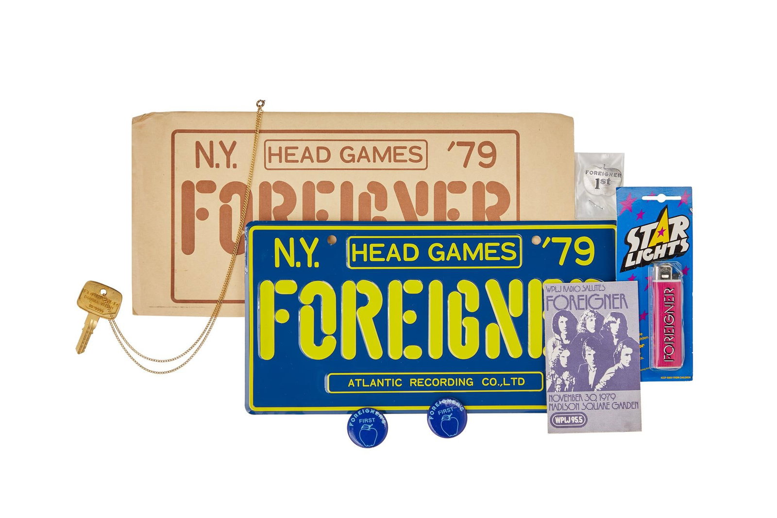 Foreigner | Vintage Memorabilia: A group of vintage memorabilia related to the band Foreigner, including: A metal "Head Games" license plate, with paper sleeve, 6 x 12 inches. A "Double Vision" key wit