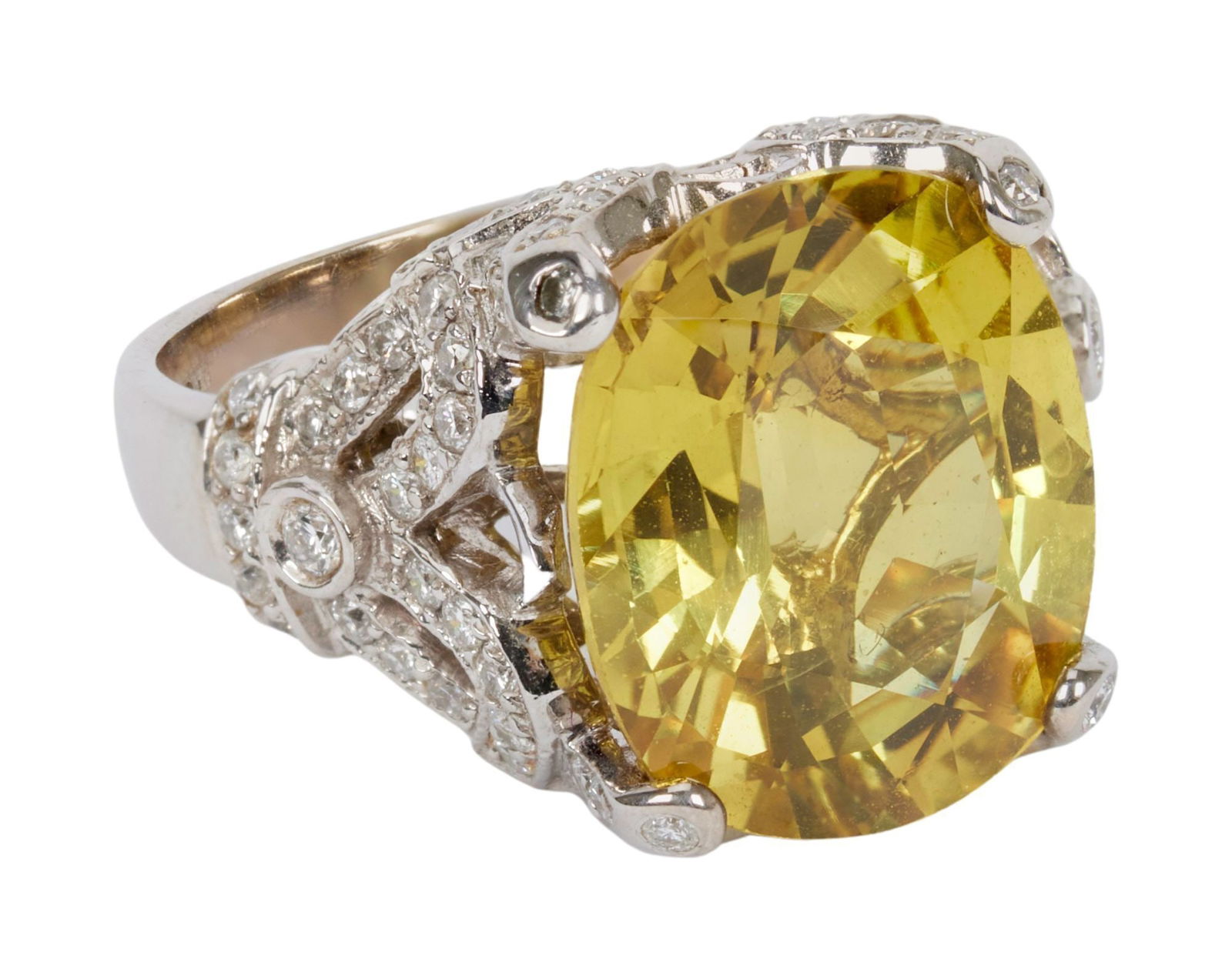 Whoopi Goldberg | 18k White Gold Yellow Sapphire and Diamond Ring: Centering upon an oval-cut yellow sapphire joined to the circular-cut diamond foliate designed shoulder and prongs and polished, 18k white gold hoop 8.8 grams, ring size 6.25.Condition: 80 circul