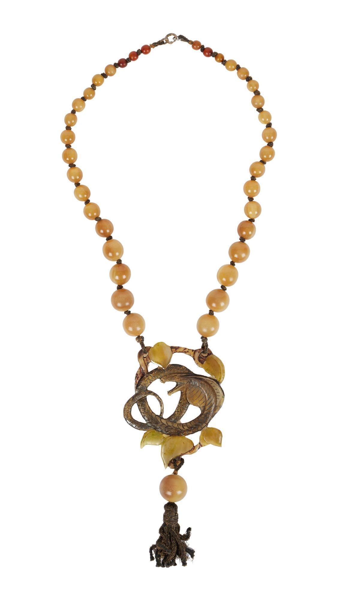 Whoopi Goldberg | Art Nouveau Horn Pendant Necklace: The graduated horn bead necklace set to the front, with a carved horn cobra plaque suspending a fabric and bead tassel, 23 1/2 inches, tassel 6 1/2 inches, the verso inscribed "elgi." From the Collect