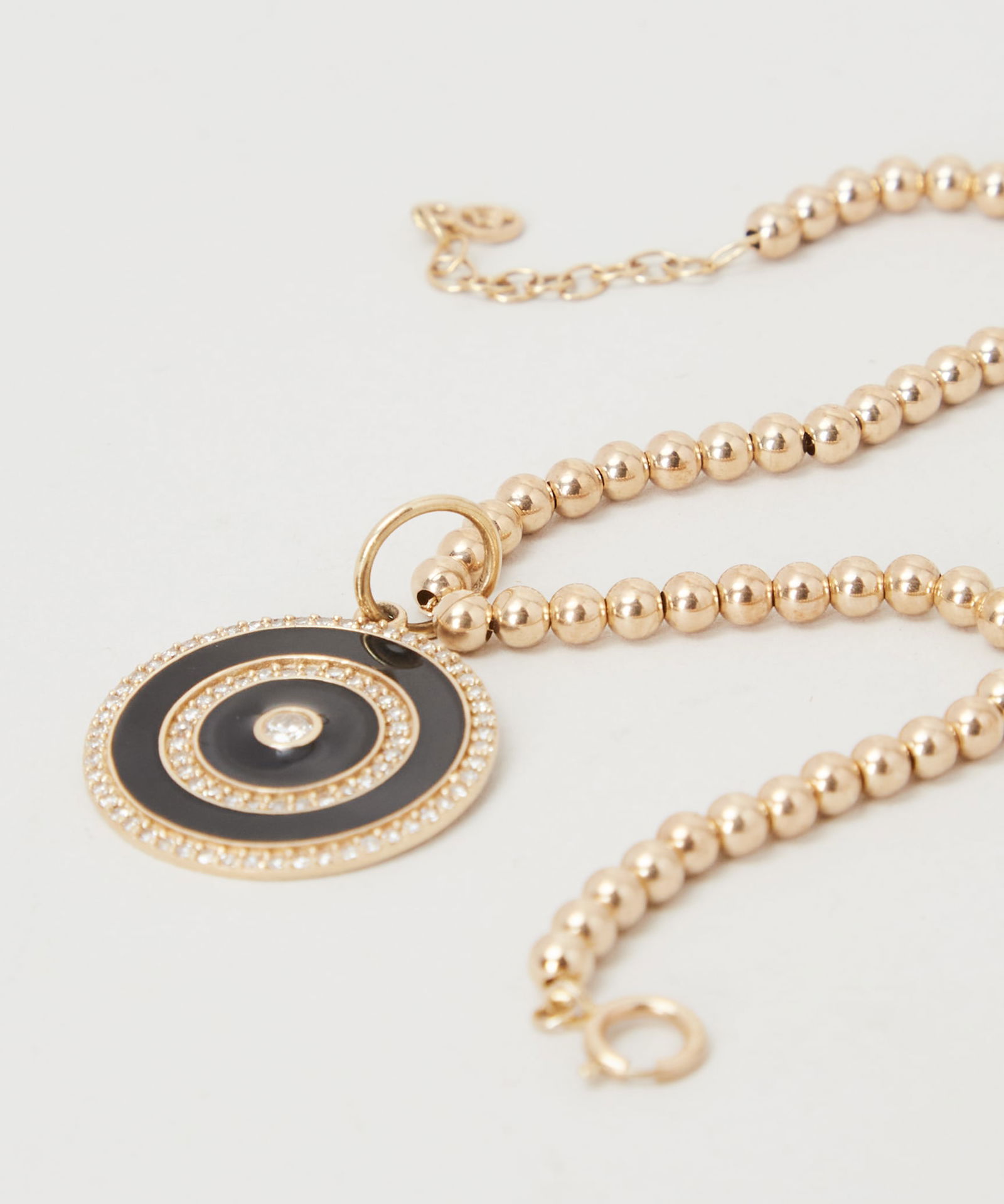 Gwyneth Paltrow | 14k Gold Beaded Bracelet with Pendant: A 14k yellow gold bead bracelet from the collection of Gwyneth Paltrow.Suspending a circular black enamel pendant accented with a diamond. Marked 14k.Gwyneth Paltrow is a true muse when it comes