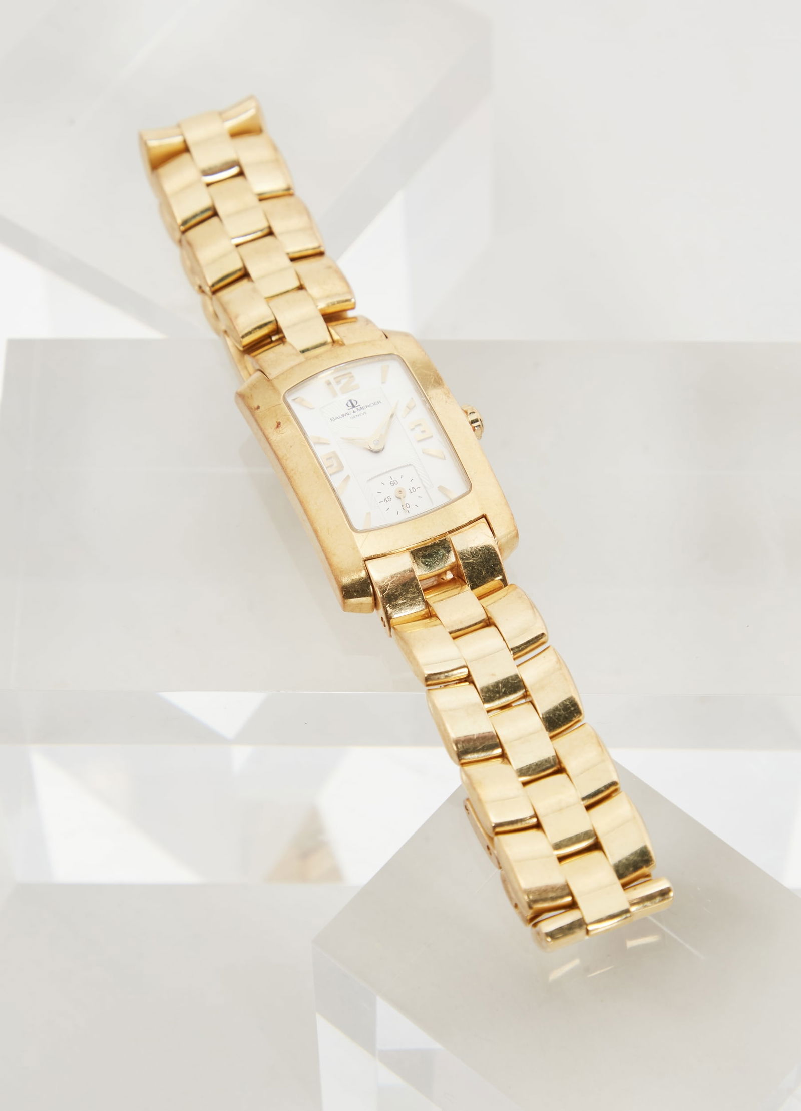 Gwyneth Paltrow | BAUME & MERCIER 18K Yellow Gold Hampton Milleis Wristwatch: BAUME & MERCIER, 18K Yellow Gold “Hampton Milleis” Wristwatch from the collection of Gwyneth Paltrow.Featuring a quartz movement, the rectangular cushion-shaped white dial is detailed with