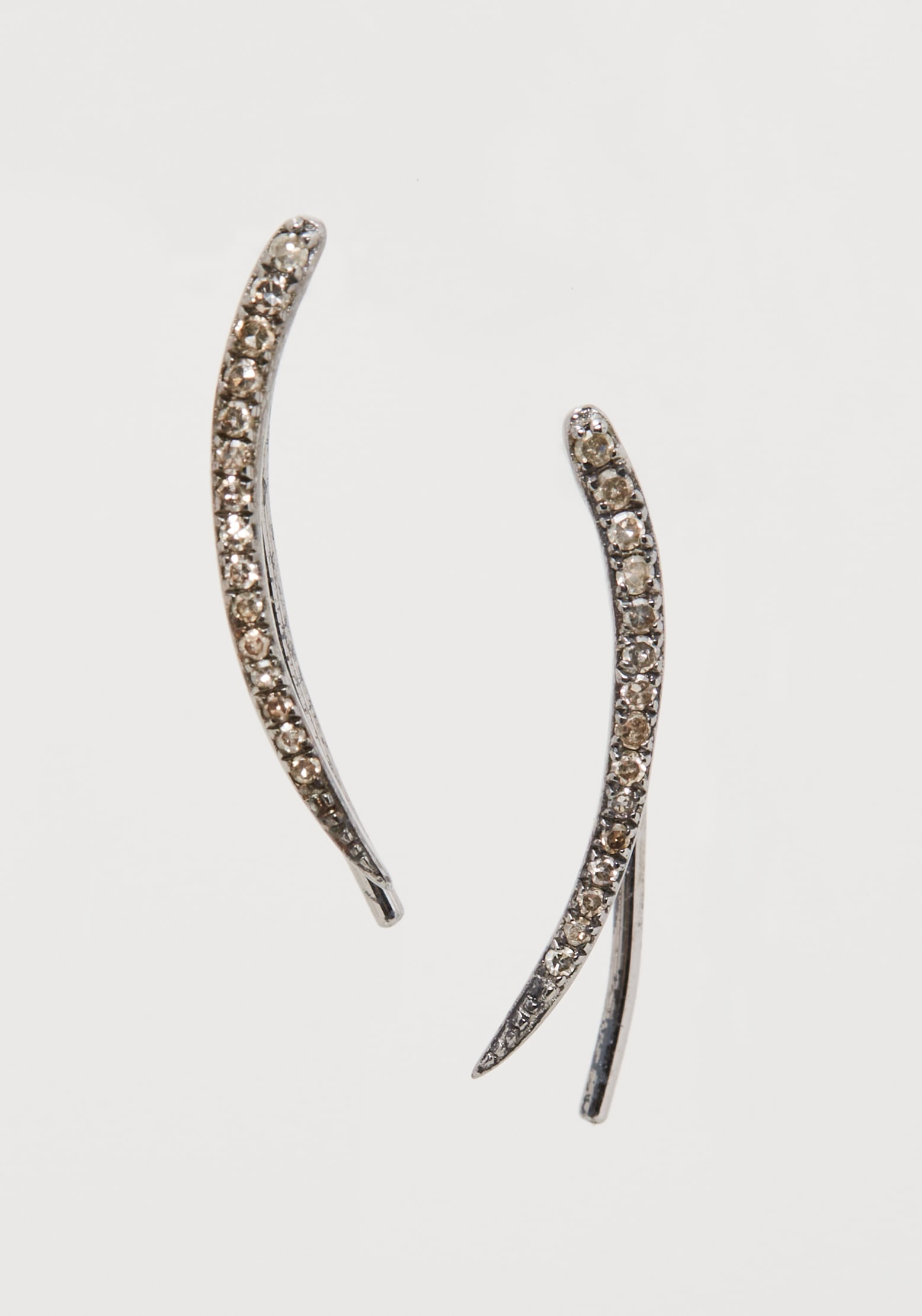 Gwyneth Paltrow | Colored Diamond Ear Crawlers: Colored diamond ear crawlers from the collection of Gwyneth Paltrow.Each earring is designed as a curved line of single-cut grey diamonds mounted in silver metal. Unmarked.Gwyneth Paltrow is a true mu