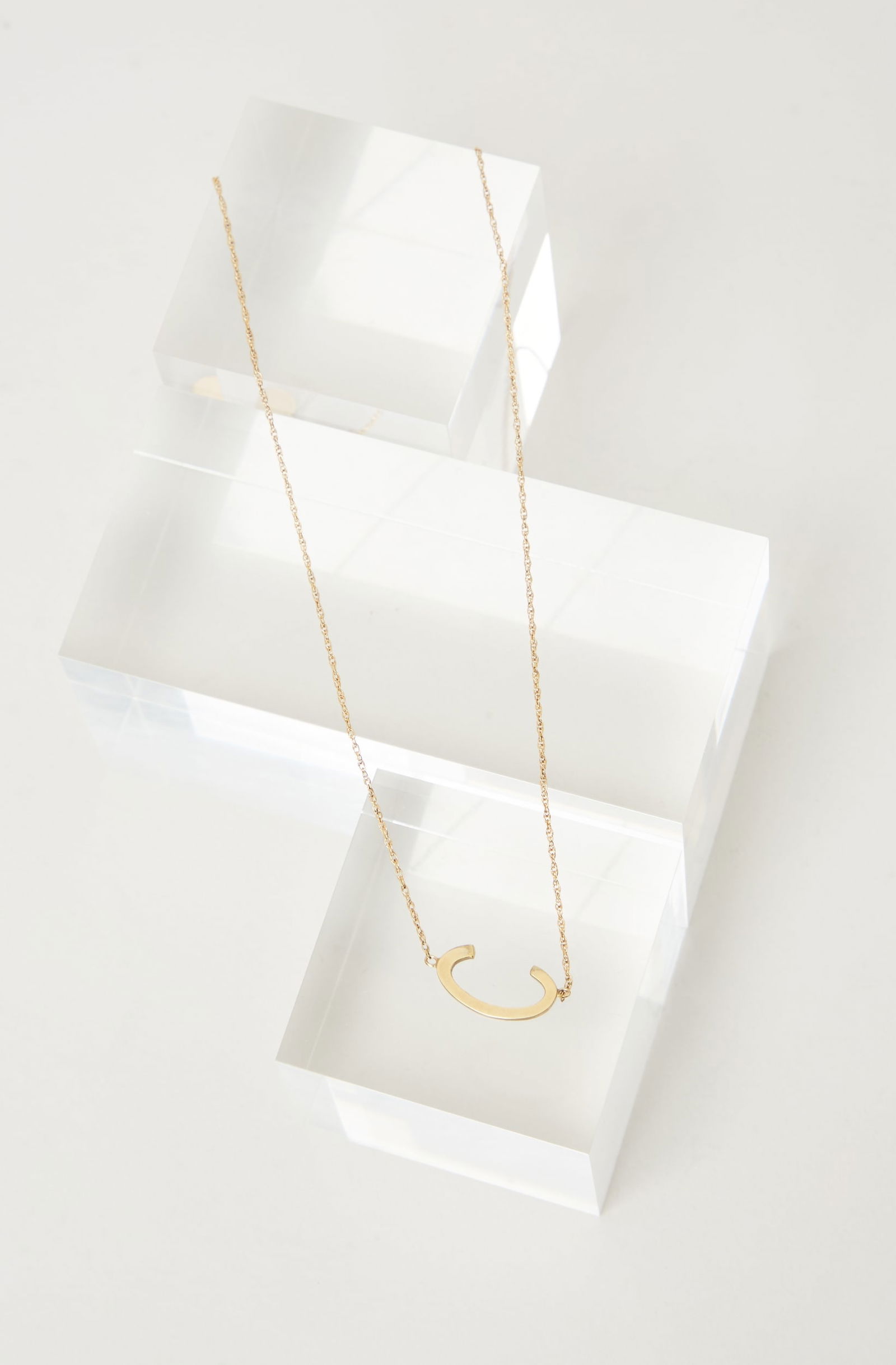 Gwyneth Paltrow | Jane Basch Necklace: A Jane Basch Design necklace from the collection of Gwyneth Paltrow.The pendant features a horizontal polished letter “C”, suspended from a fine-link chain. Marked: Jane Basch