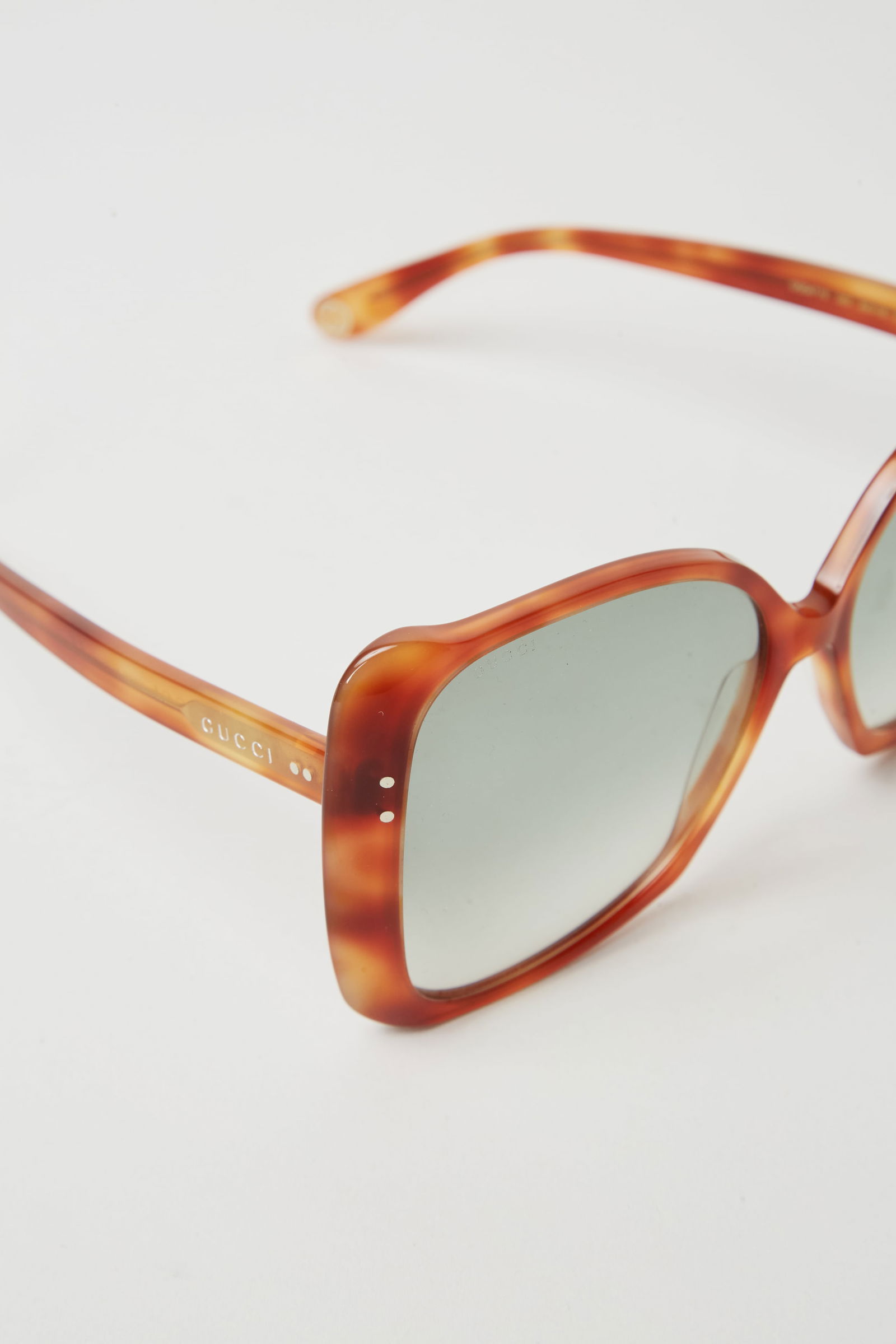 Gwyneth Paltrow | Gucci Havana Square Sunglasses: Gucci Havana square sunglasses from the collection of Gwyneth Paltrow. Gucci oversize sunglasses in an orange tortoise shell acetate with interlocking G logo. Tinted lens. Made in Italy. Com