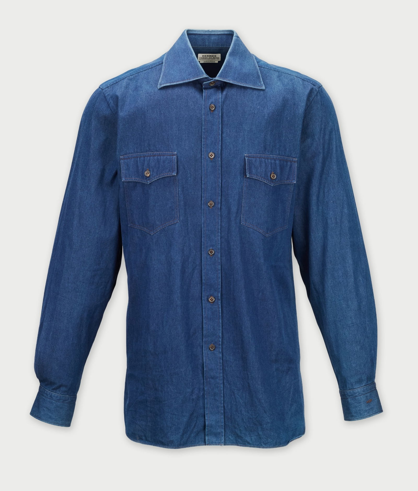 Hermès | Blue Denim Buton-Down Shirt: A long-sleeve button-down shirt designed by Hermès, from the collection of Cameron Silver.A medium-blue cotton denim with a soft wash, and brown stitching. The piece is tailored for a relaxed