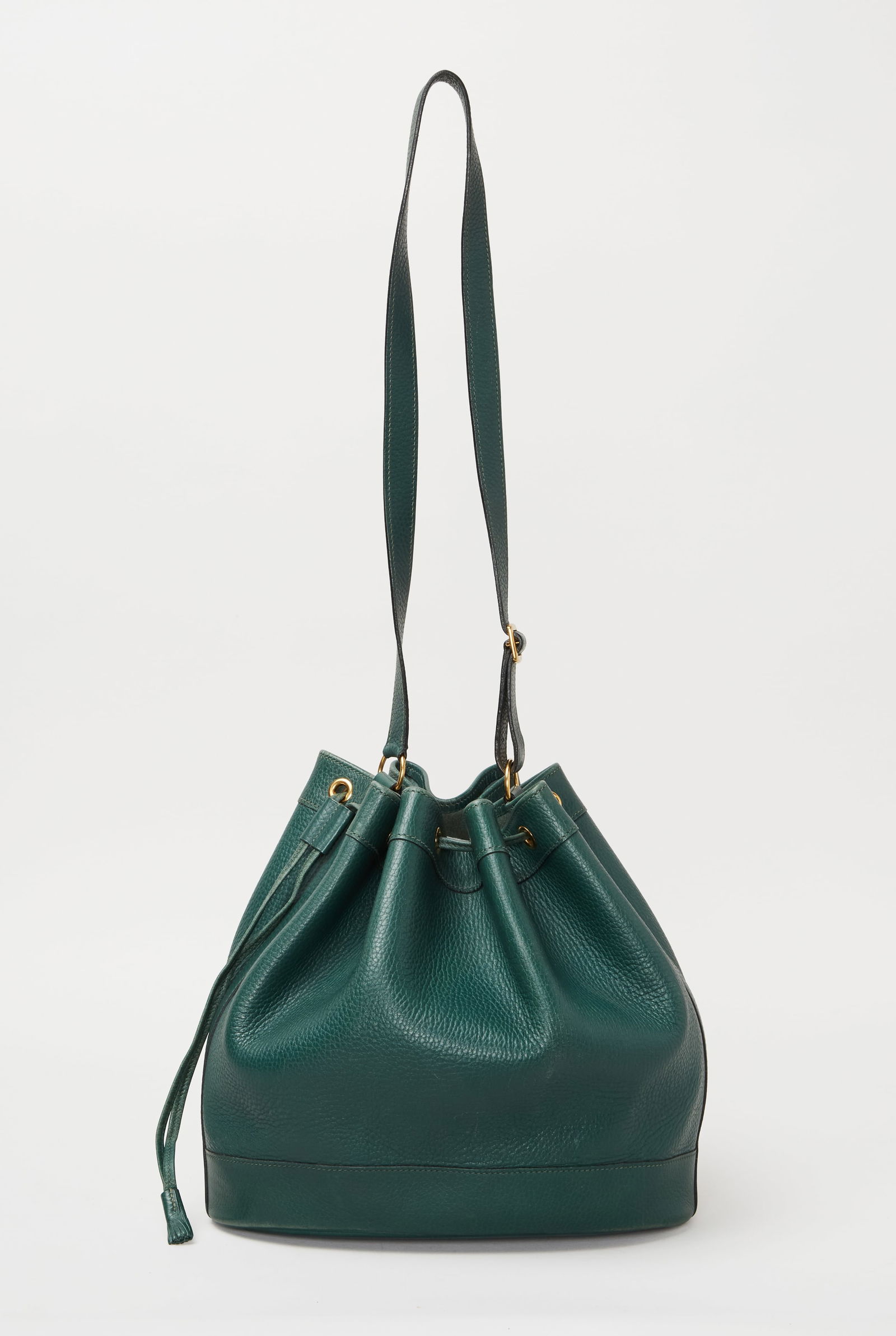 Hermès | 1991 Courchevel Market Drawstring Bag 28: Hermès 1991 Courchevel Market Drawstring Bag 28.A tourillion green leather drawstring bag. The bag features an adjustable leather shoulder strap and a leather cinch cord with gold hardware. The