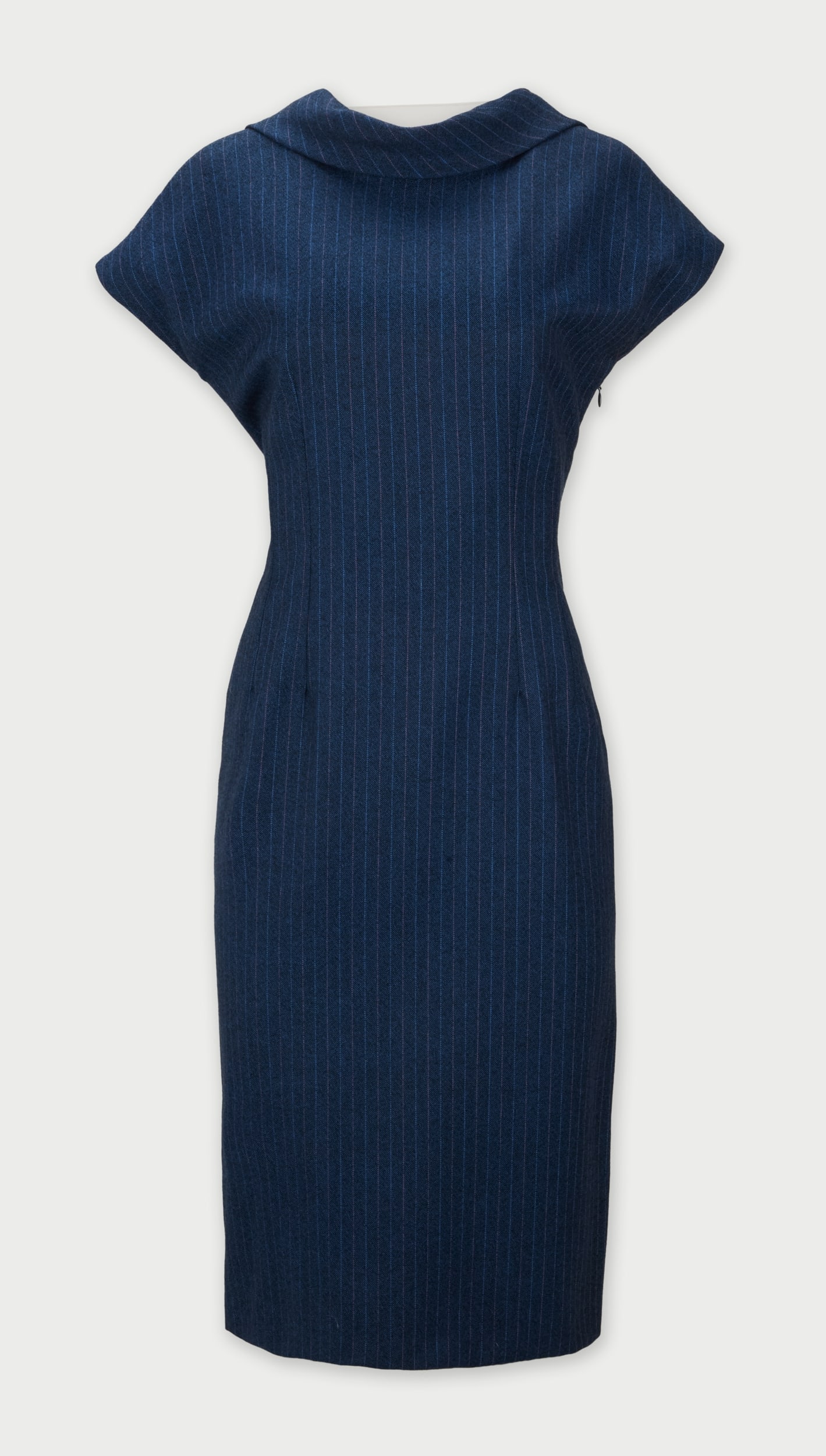 Givenchy | 1998-1999 Fall Collection By Alexander McQueen “Blade Runner” Navy Wool: This is a navy wool pinstripe patterned mid-length dress designed by Alexander McQueen for the house of Givenchy fall 1998-1999 collection. McQueen employs his tailoring skills to the streamline