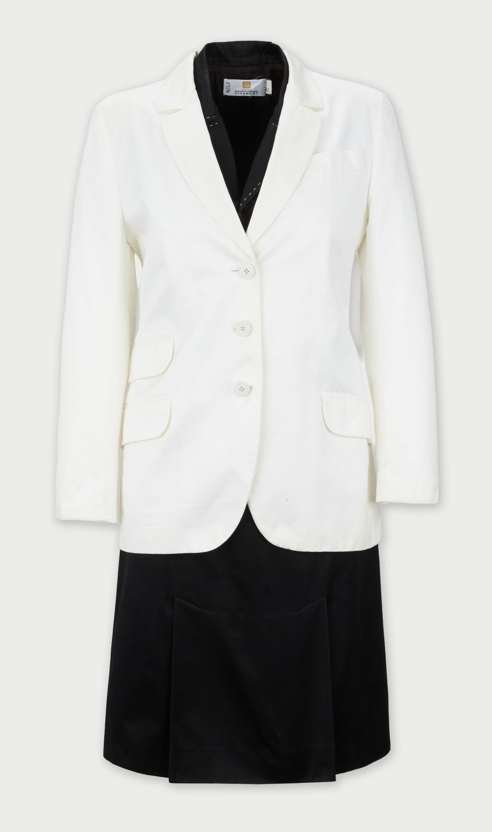 Givenchy | 1999 Spring Runway Collection By Alexander McQueen Two-Piece Dress Ensemble: A two-piece dress ensemble that includes a black A-line shift dress with box pleated skirt and a single-breasted white blazer designed by Alexander McQueen for the spring 1999 runway collection titled