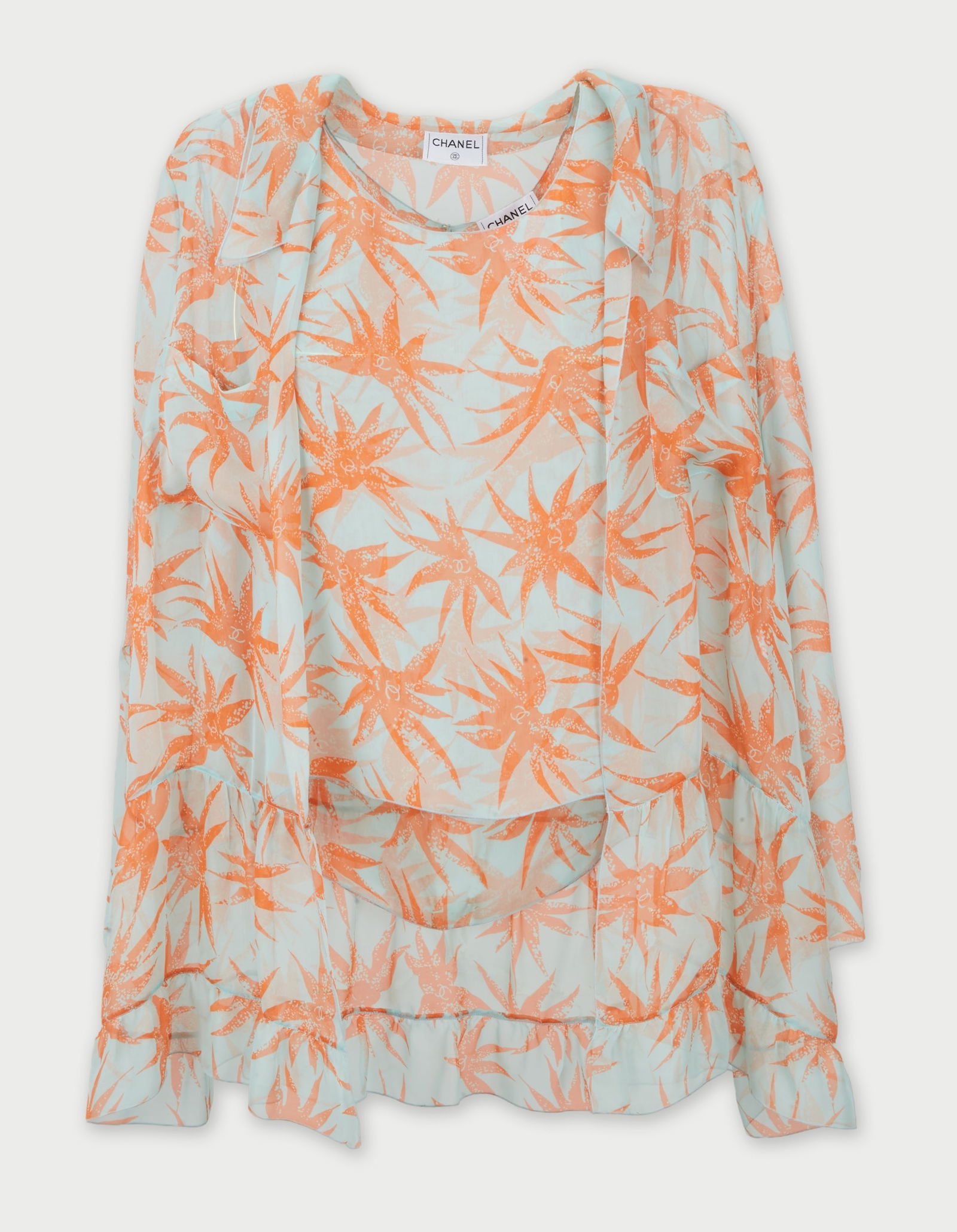 Chanel | 2000 Cruise Collection Patterned Blouse And Cover-Up: Chanel by Karl Lagerfeld 2000 Cruise collection sheer silk shirt and blouse.The 100% silk set features the print, star-shaped botanical motifs in orange set against a blue background, with the iconic