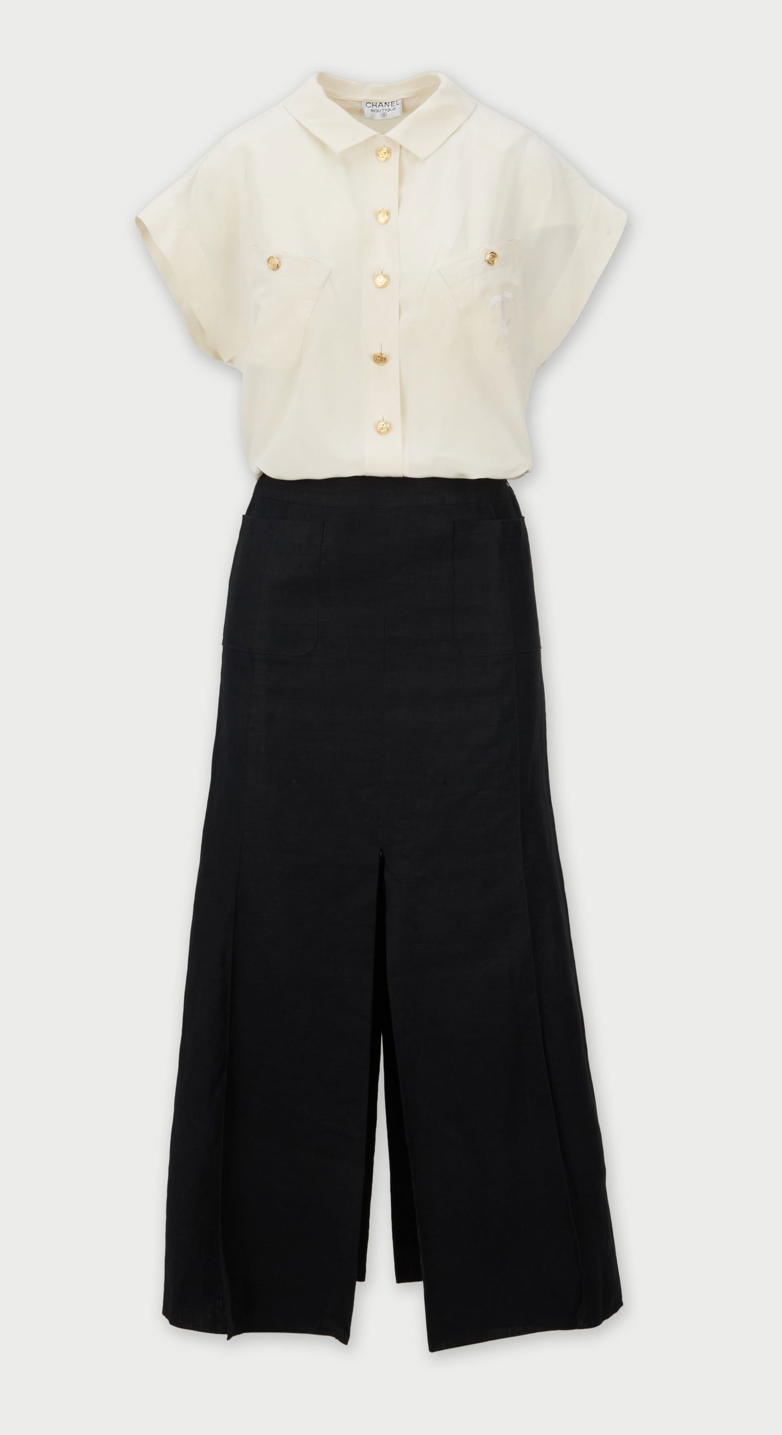 Chanel | Vintage Silk Blouse And Linen Skirt Ensemble: A Chanel blouse and skirt ensemble featuring a cream silk blouse and a linen long dark indigo linen skirt.The blouse features a classic pointed collar and a straight, boxy silhouette. The blouse