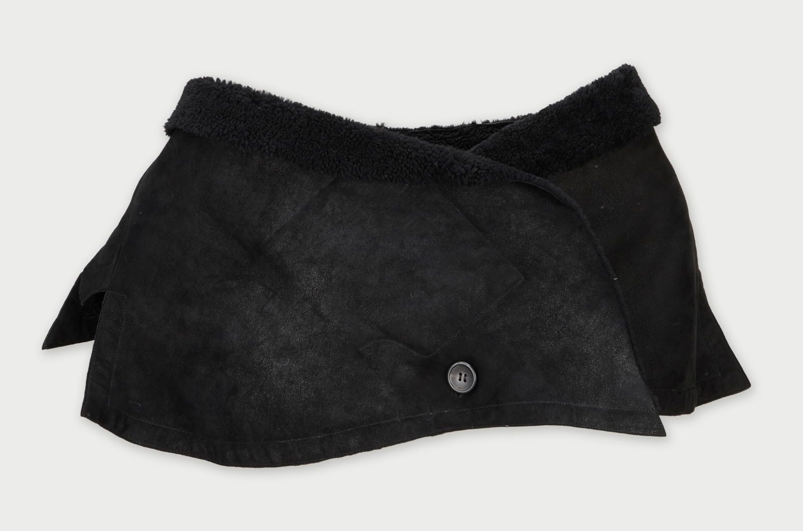 John Galliano | Shawl: A black shawl designed by John Galliano, from the collection of Cameron Silver. Crafted in a soft black suede that forms an asymmetric silhouette, the piece is fully lined in plush black sherpa.