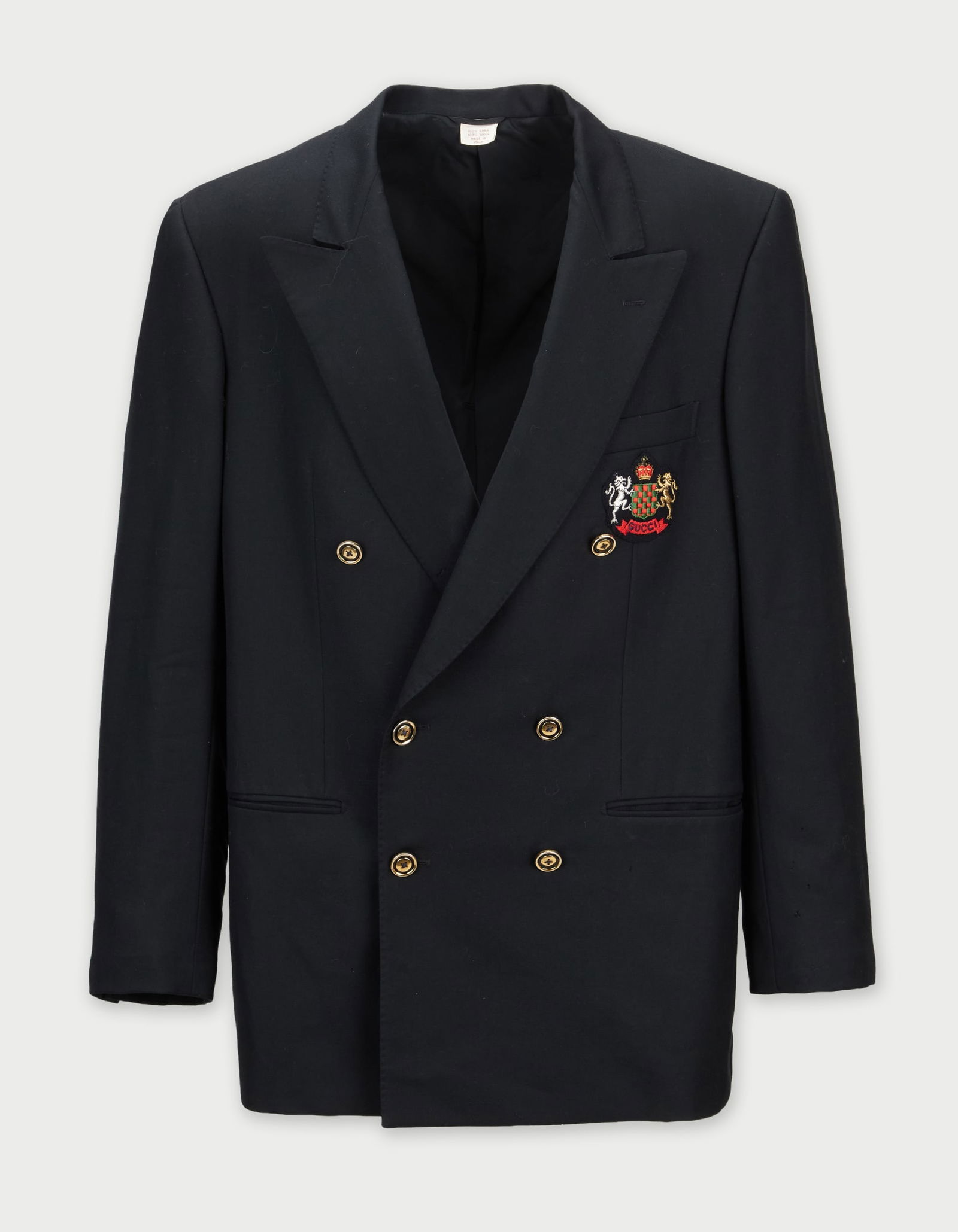Gucci | Heraldic Crest Blazer: A double-breasted black blazer designed by Gucci, from the collection of Cameron Silver. The wool jacket features a sharp, tailored silhouette with broad, notched lapels. The closure is secured b