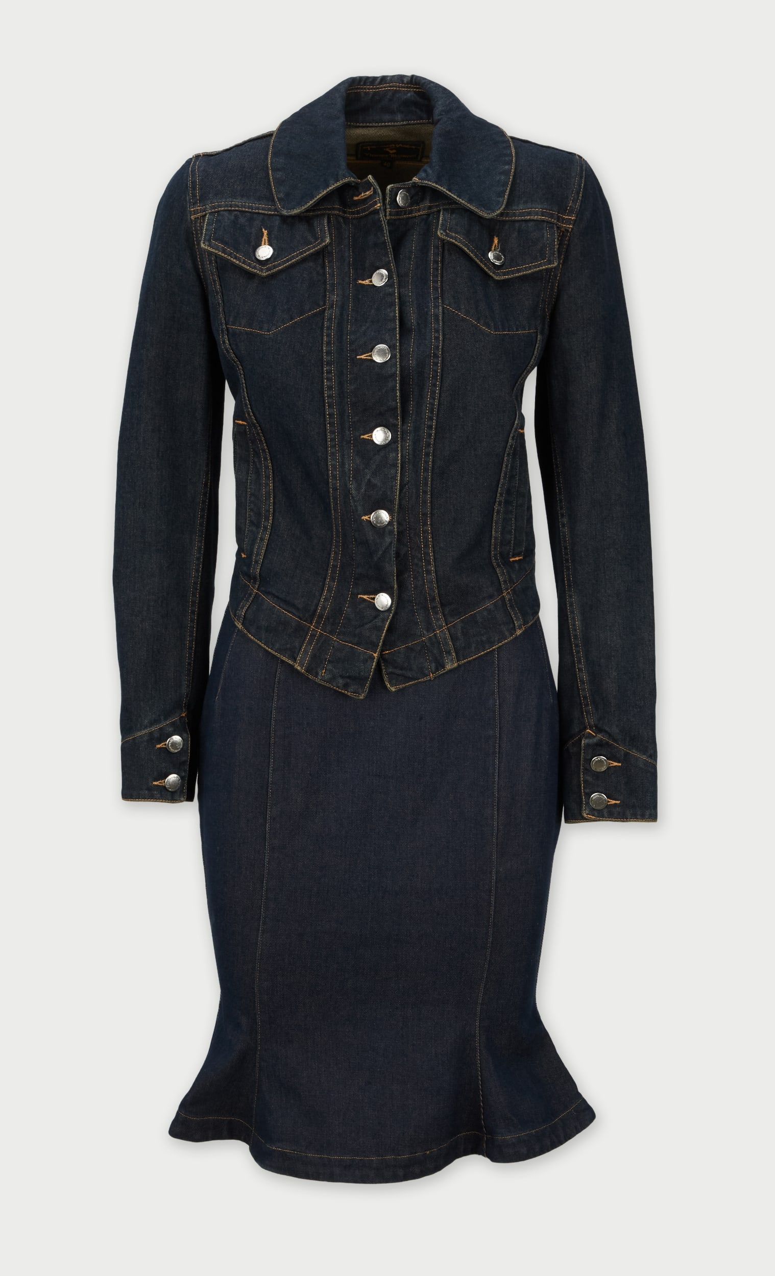 Vivienne Westwood | Dark-Wash Denim Jacket and Skirt Ensemble: A Vivienne Westwood dark-wash denim jacket and skirt ensemble. The ensemble is a cotton blend material. The jacket has contrasting topstitching, pointed collar, button-front closure, flap chest