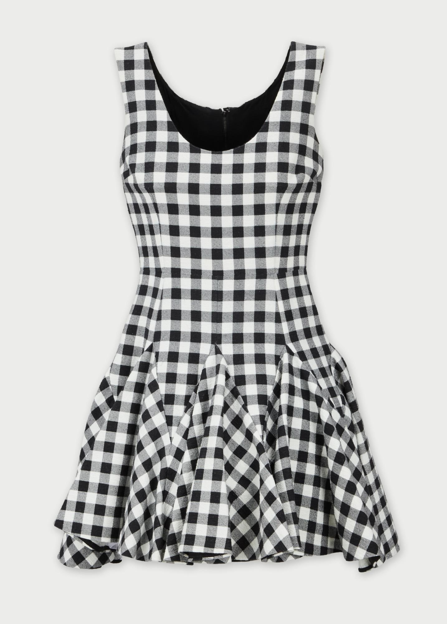 Dolce and Gabbana | Black And White Checkered Day Dress: A Dolce and Gabbana black and white cotton blend checkered print dress with wide shoulder straps, a scoop neckline, fitted bodice, concealed back zipper, and a flared skirt made with inverted pleats.