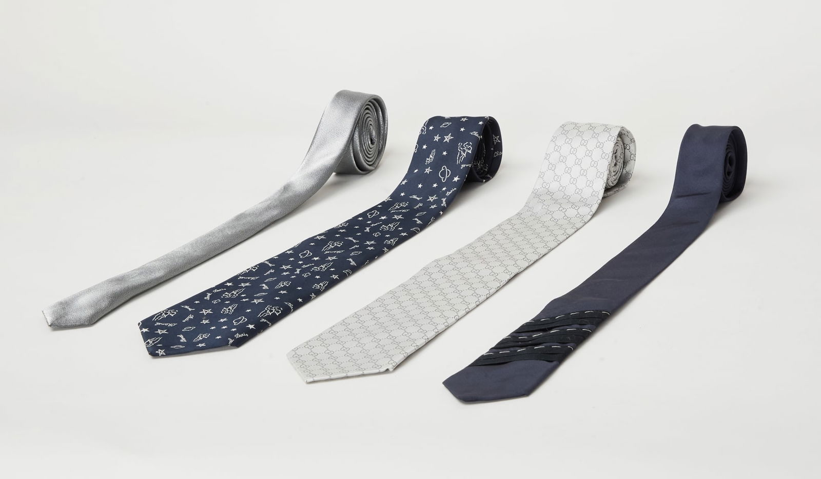 Designer Ties | Four Designer Neck Ties (Chanel, Dior, Gucci, and Lanvin): A grouping of four men's designer neck ties, each designed a different brand/fashion house. The first is from Chanel featuring a novelty print and insignia (Length: 55.75 inches), composed of