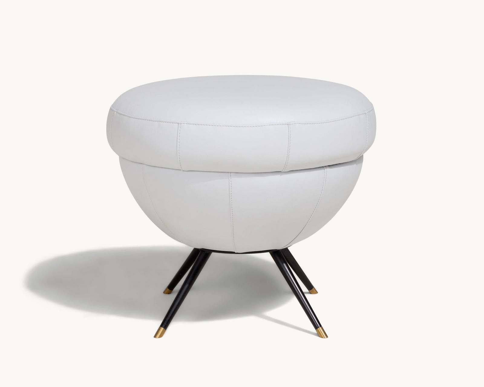 Gwyneth Paltrow | Mid-century Modern style Leather Stool: A round stool with a dove leather upholstered seat and brass-capped black metal legs.This item comes from Gwyneth Paltrow’s Hamptons home, a peaceful retreat designed for comfort and wellness. T