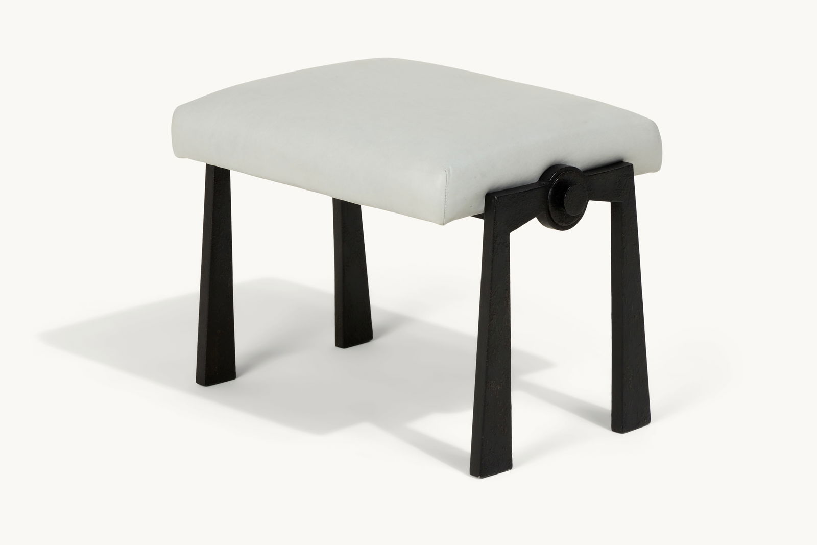 Gwyneth Paltrow | Leather Stool with Iron Base: A rectangular stool with a dove grey leather upholstered seat and reverse tapering iron legs.This item comes from Gwyneth Paltrow’s Hamptons home, a peaceful retreat designed for comfort and wel