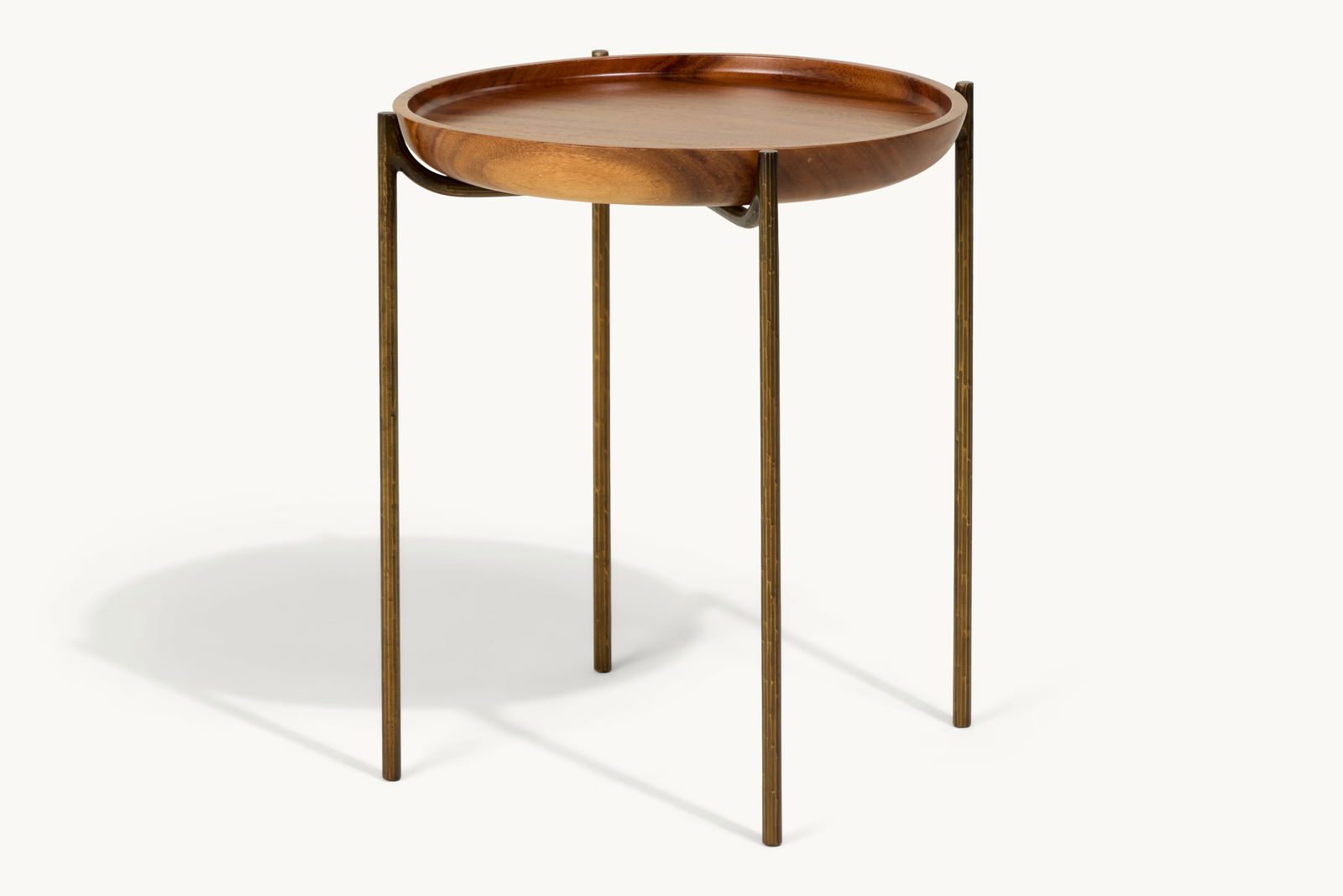Gwyneth Paltrow | Teak and Patinated Bronze Occasional Table: A circular tray table inset on a patinated bronze base with X-form top. With an "H.D. Buttercup" label on the underside.This article is from Gwyneth Paltrow’s former Brentwood home in Los Angele