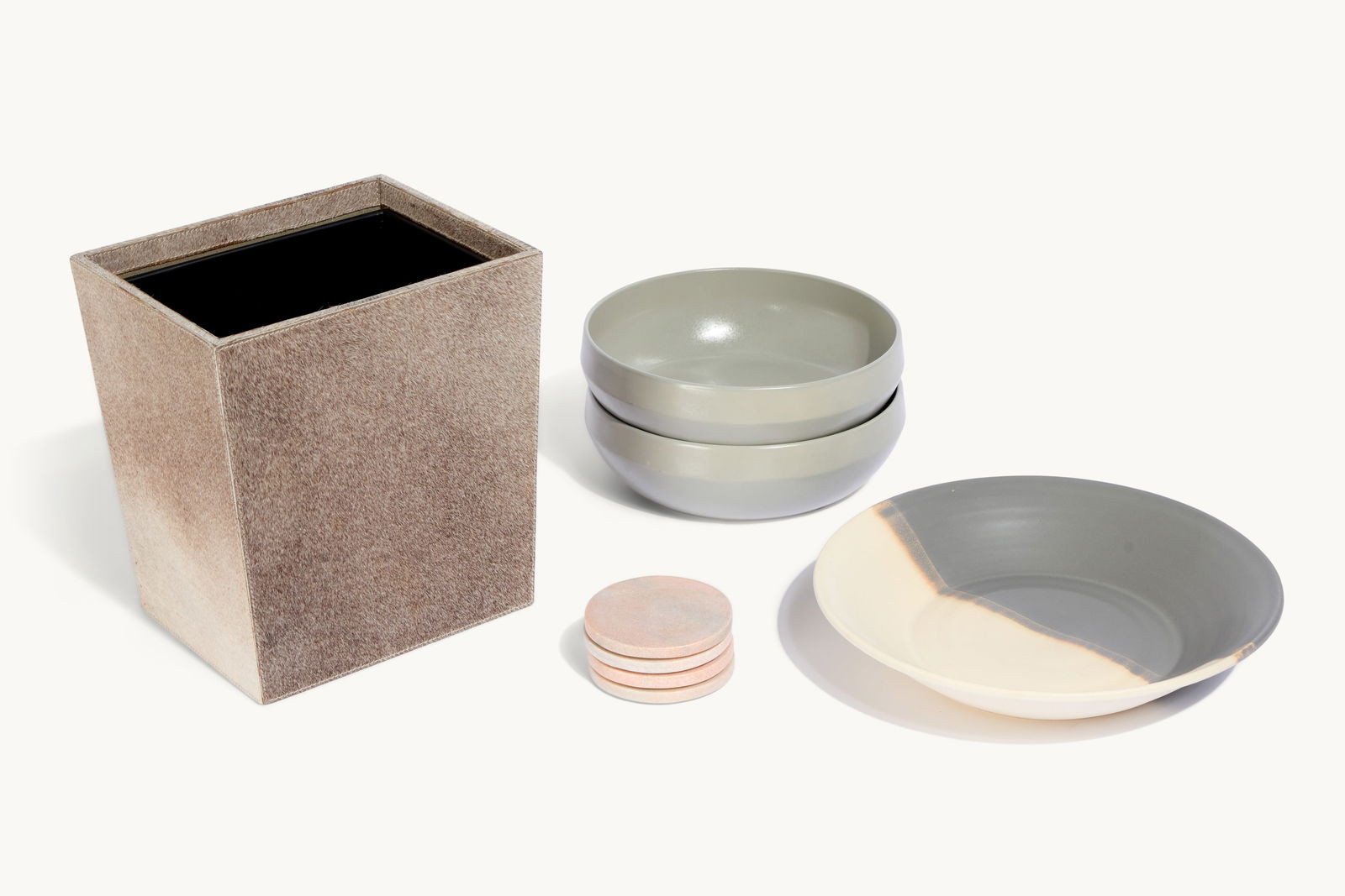Gwyneth Paltrow | Group of Hide Ceramic and Stone Decorative Items: Including a hide Pigeon & Poodle wastebasket with metal liner, a contemporary studio art pottery ceramic bowl marked "Made in Los Angeles," a set of four pink marble round coasters, and two grey Crate