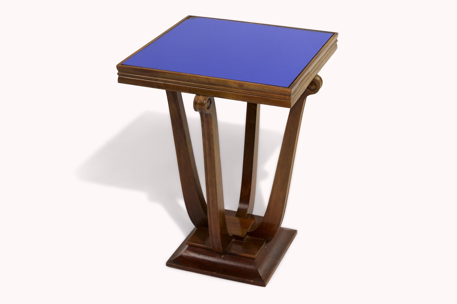 And Just Like That... | Joy's French Art Deco Occasional Table: A French Art Deco occasional table with a blue cobalt glass top and curved leg supports on a square plinth base. This table was located in Joy's apartment. A one-time donation will be made by Warner B