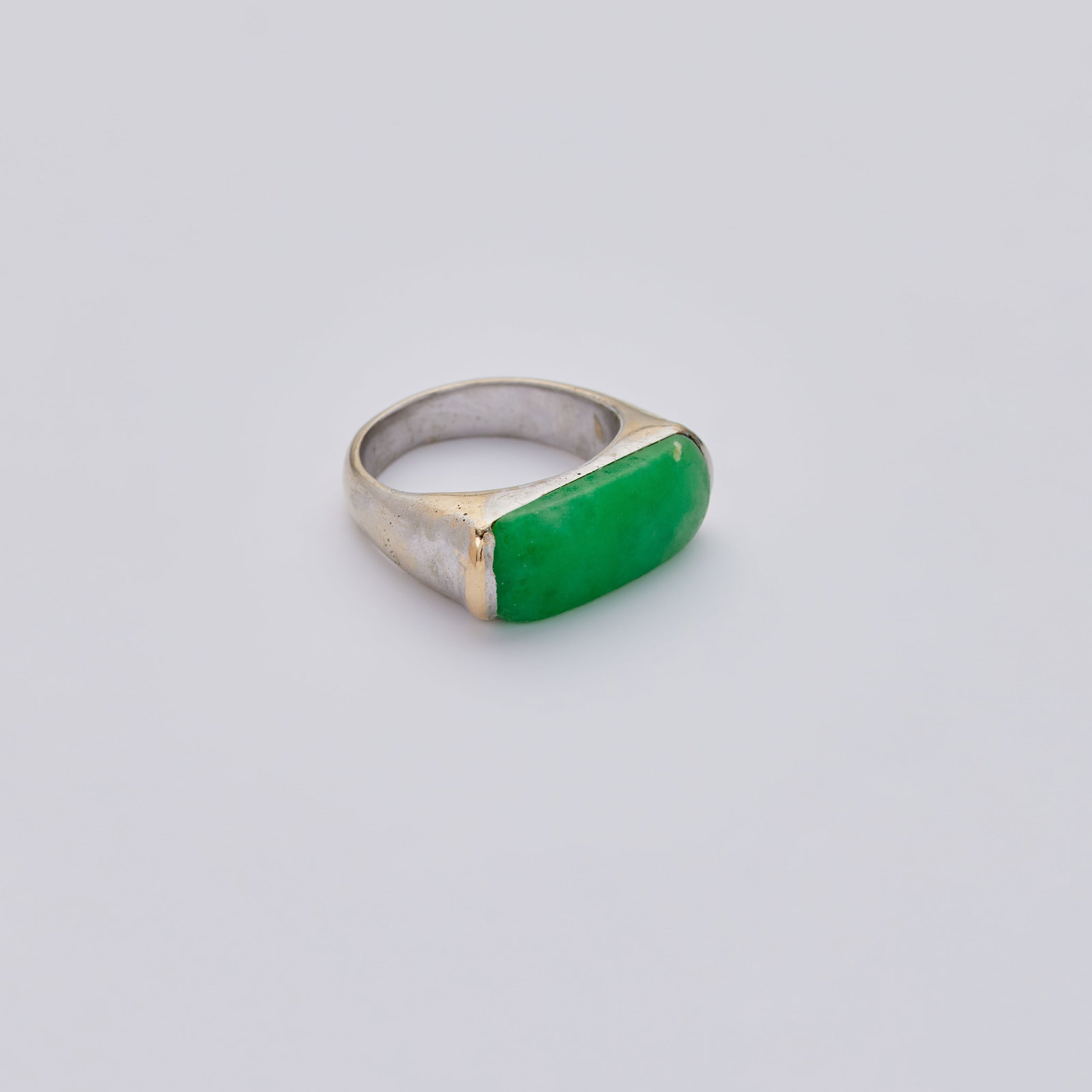 Jerry Weintraub | 18K White Gold and Jadeite Saddle Ring: An original 18k white gold and jadeite saddle ring owned and worn by Jane Morgan.The ring is set to the top with an elongated green jadeite panel, mounted in 18k white gold, ring size 7, 8.2
