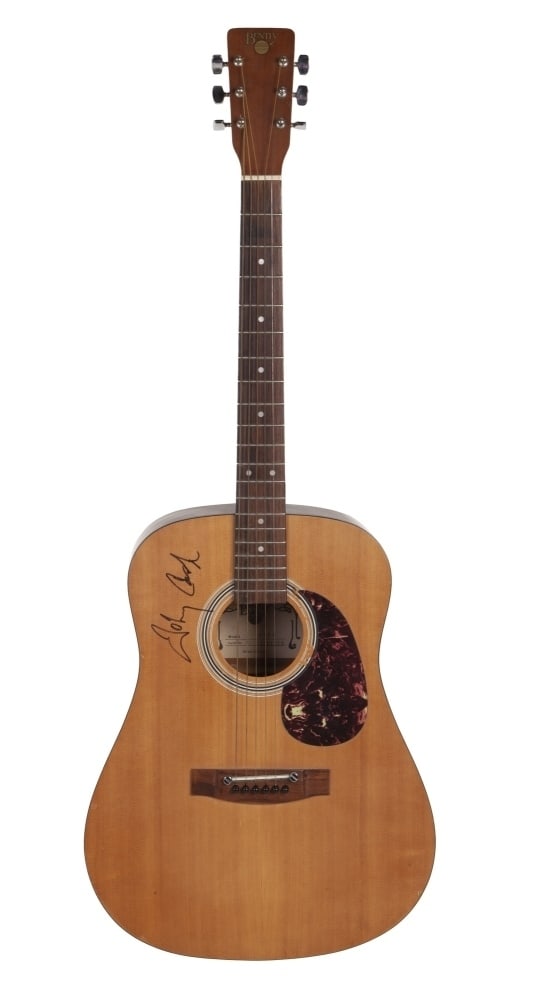 Johnny Cash | Signed and Personally Owned Bently Acoustic Guitar: A c. 1980s Bently 5106 acoustic guitar serial number 83101259 in satin natural finish. Owned played and signed by Johnny Cash on the top in black felt tip pen. The guitar was kept in Cash's home o