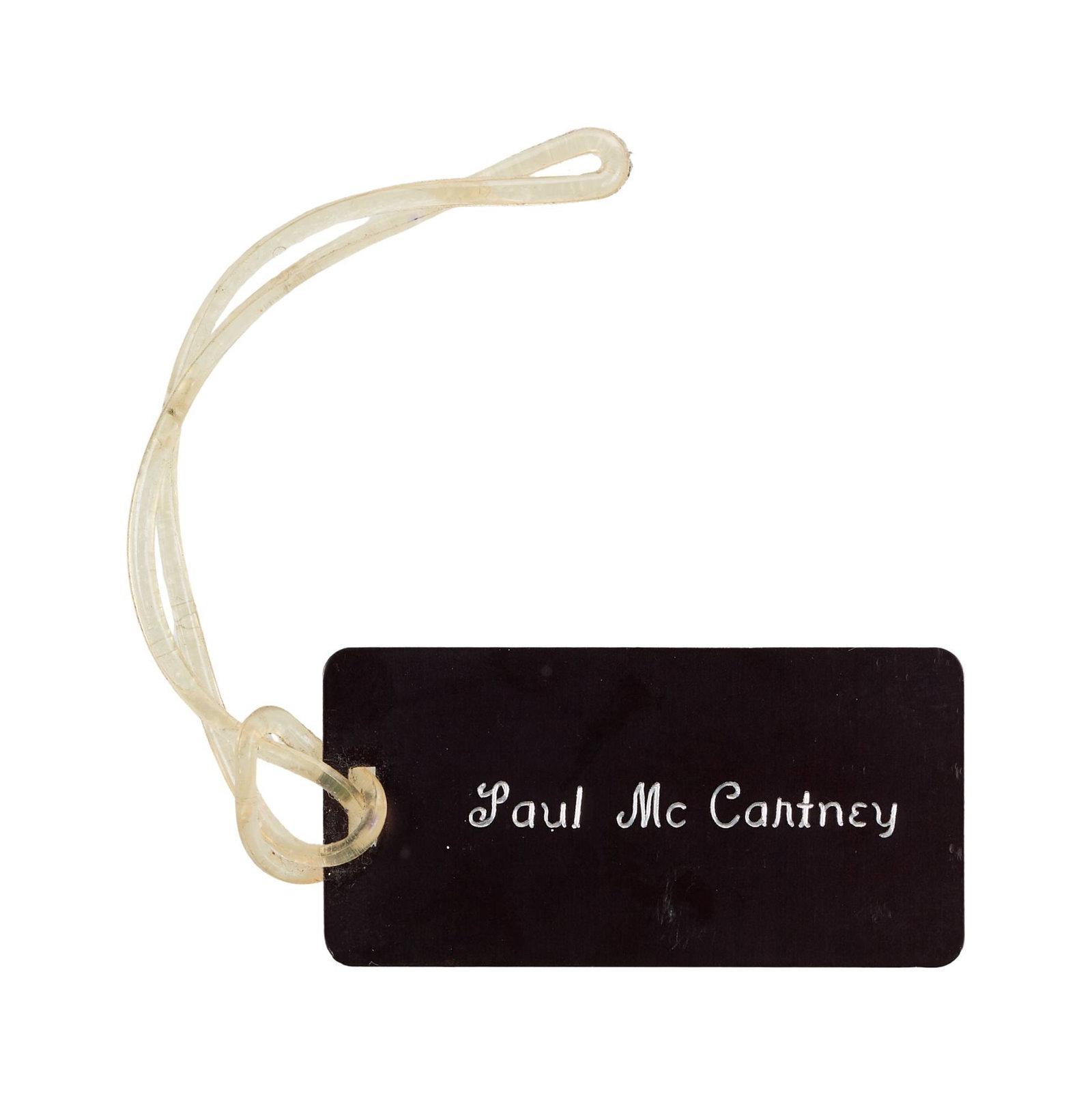 Paul McCartney | 1976 Chicago Limousine Service Baggage Tag: An original Chicago Limousine Service baggage tag personally owned by Paul McCartney and used by him while on tour with Wings in the spring of 1976. The black plastic tag reads "Chicago