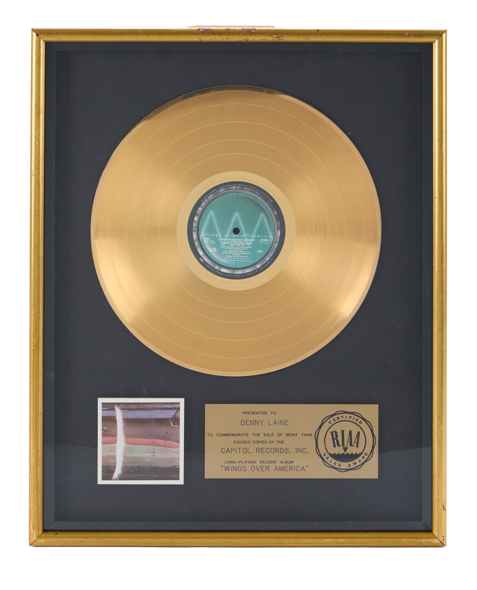 Denny Laine | RIAA "Gold" Sales Award for "Wings Over America": An RIAA-Certified "Gold" sales award presented to Denny Laine to commemorate the sale of more than 500,000 copies of Paul McCartney & Wings 1976 live album Wings Over America. The triple live