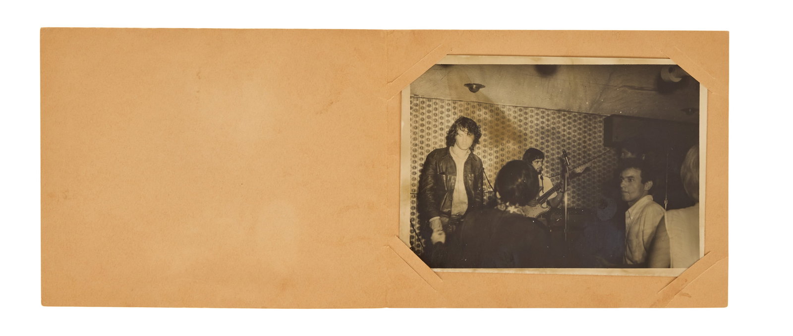Jim Morrison | Original 1960s "Blue Note A Go-Go" Tijuana Photograph: An original black and white photograph (5 x 7 inches) featuring Jim Morrison on stage at the Blue Note bar in Tijuana, c. late 1960s. The photograph is housed in an original paper card that, on the fr