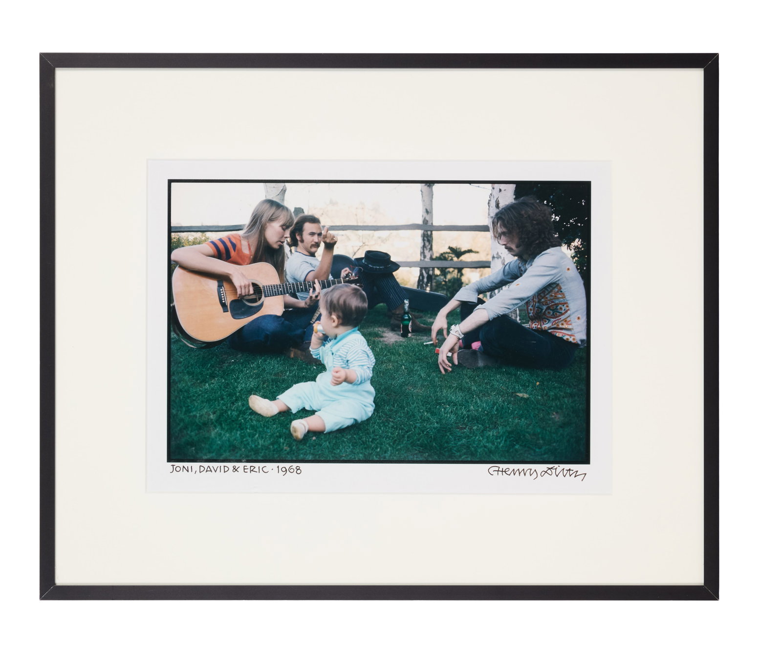Henry Diltz | Signed Color Photo of Joni Mitchell, David Crosby, and Eric Clapton: A framed color photograph of Joni Mitchell, David Crosby, and Eric Clapton, taken by Henry Diltz in 1968, signed and labeled "Joni, David & Eric - 1968" by him in black marker.