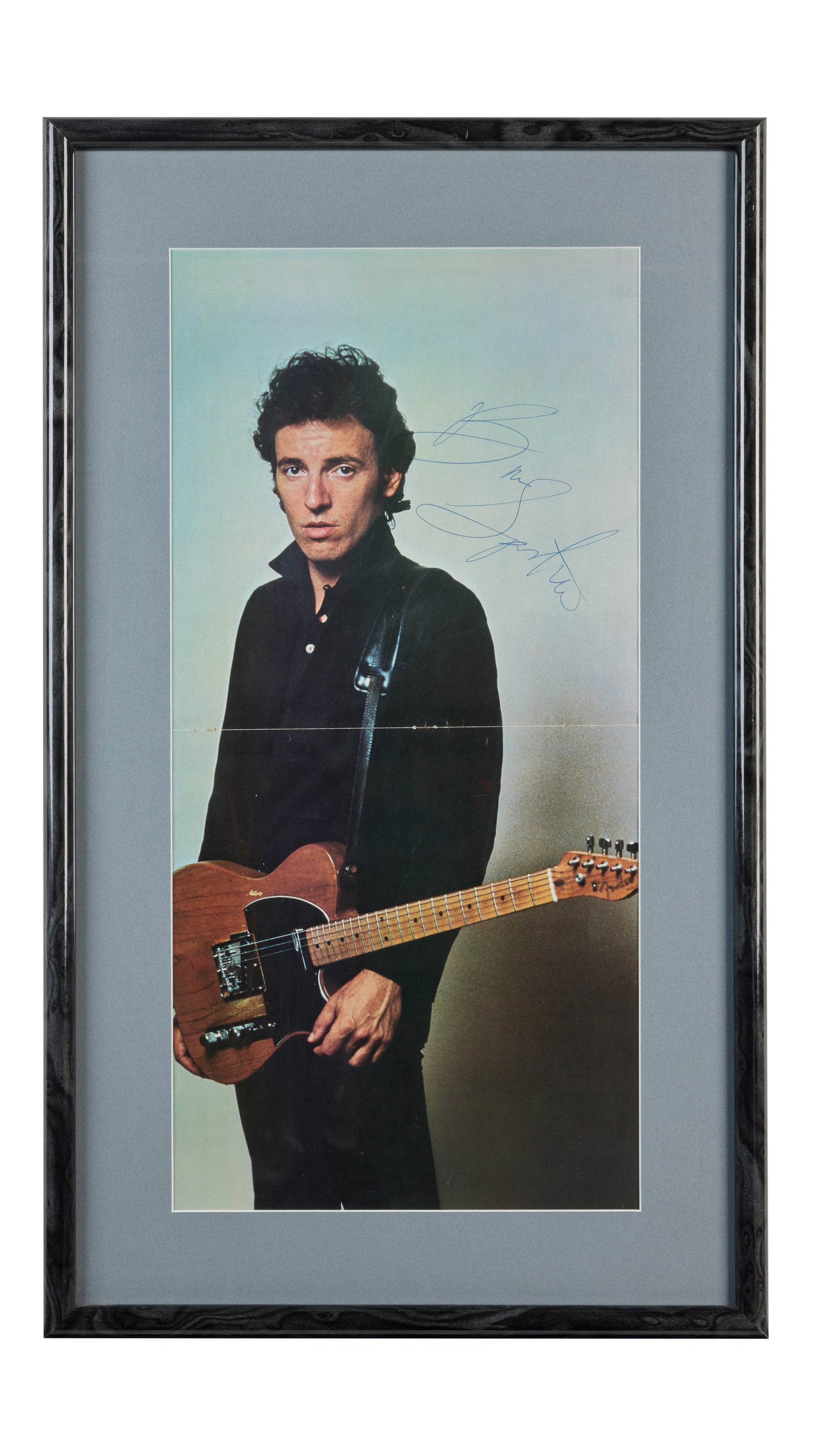 Bruce Springsteen | 1980 Signed "The River" Tour Book Centerfold Photo: The centerfold photograph of Bruce Springsteen from his 1980 The River tour book, signed by him in blue ink c. 1980-1981. The photo is framed and matted, featuring an image of Bruce with his Telecaste