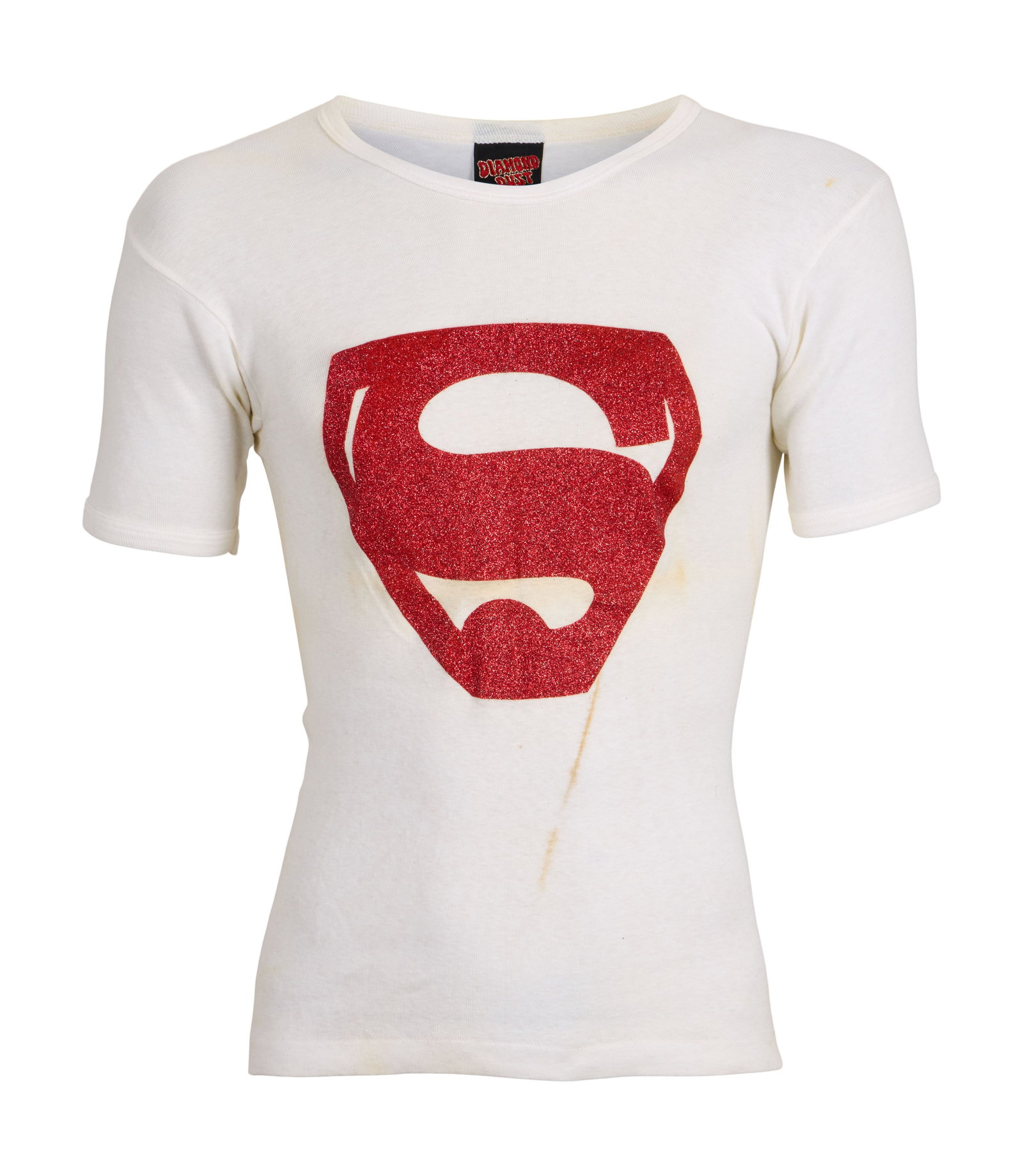 Freddie Mercury | Owned And Worn 1970s Superman T-shirt: A medium white round neck T-shirt featuring a red glittery Superman logo formerly owned and worn by Freddie Mercury in the 1970s. The label inside the collar reads "DIAMOND DUST." Originally sol