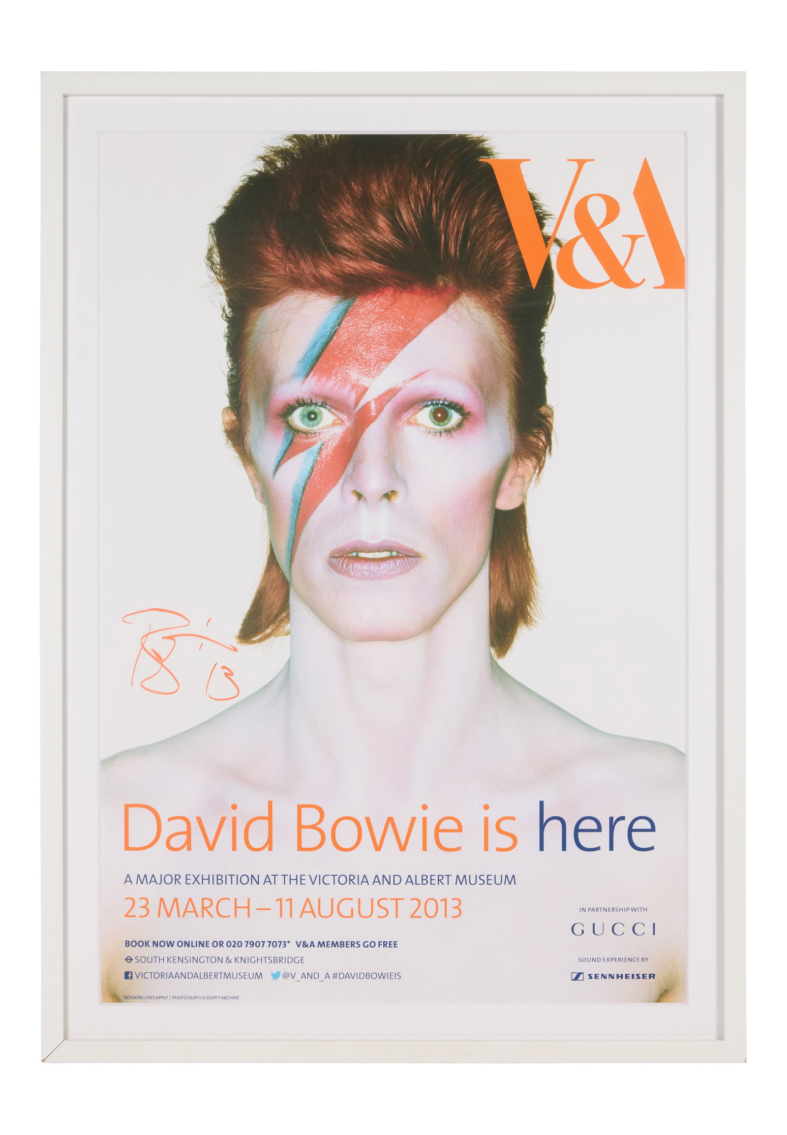 David Bowie | Signed 2013 Victoria & Albert Museum Exhibition Poster: A framed 2013 Victoria & Albert Museum poster for the "David Bowie is Here" exhibition held from March 23 to August 11, 2013, signed by Bowie on the front in orange marker. The exhibition, curat