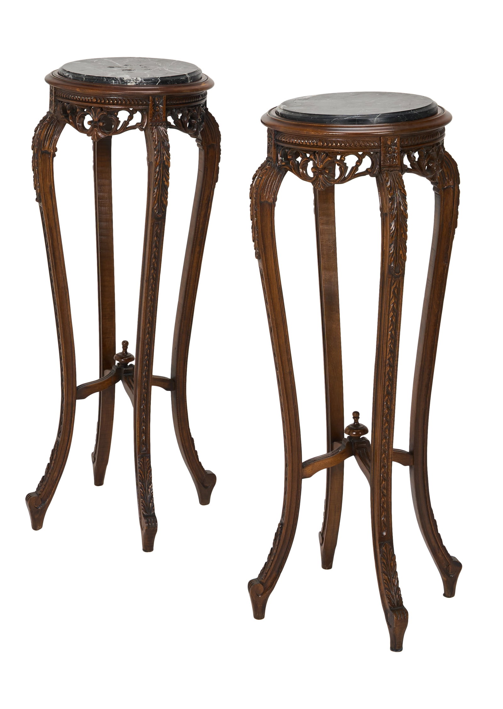 Ozzy Osbourne | Pair of Carved Stained Beech Torcheres: A pair of carved stained beech torcheres, from the collection of Ozzy Osbourne, each with a black marble top, on scroll husk and leaf carved legs. 