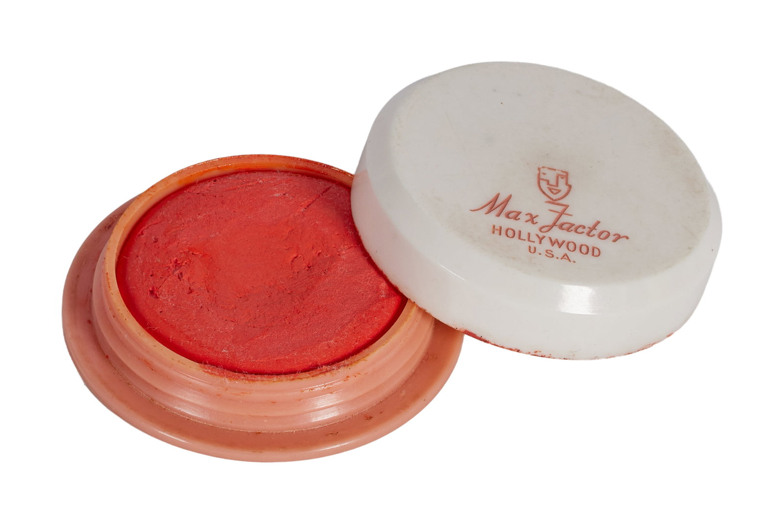 Marilyn Monroe | 1962 Lip Pomade by Max Factor: A small plastic round tub with a white lid and a pinkish-beige base; top stamped "Max Factor / Hollywood / U.S.A," bottom stamped "Lip Pomade / 7-22," inside reveals a very orange shade of lipstick pa