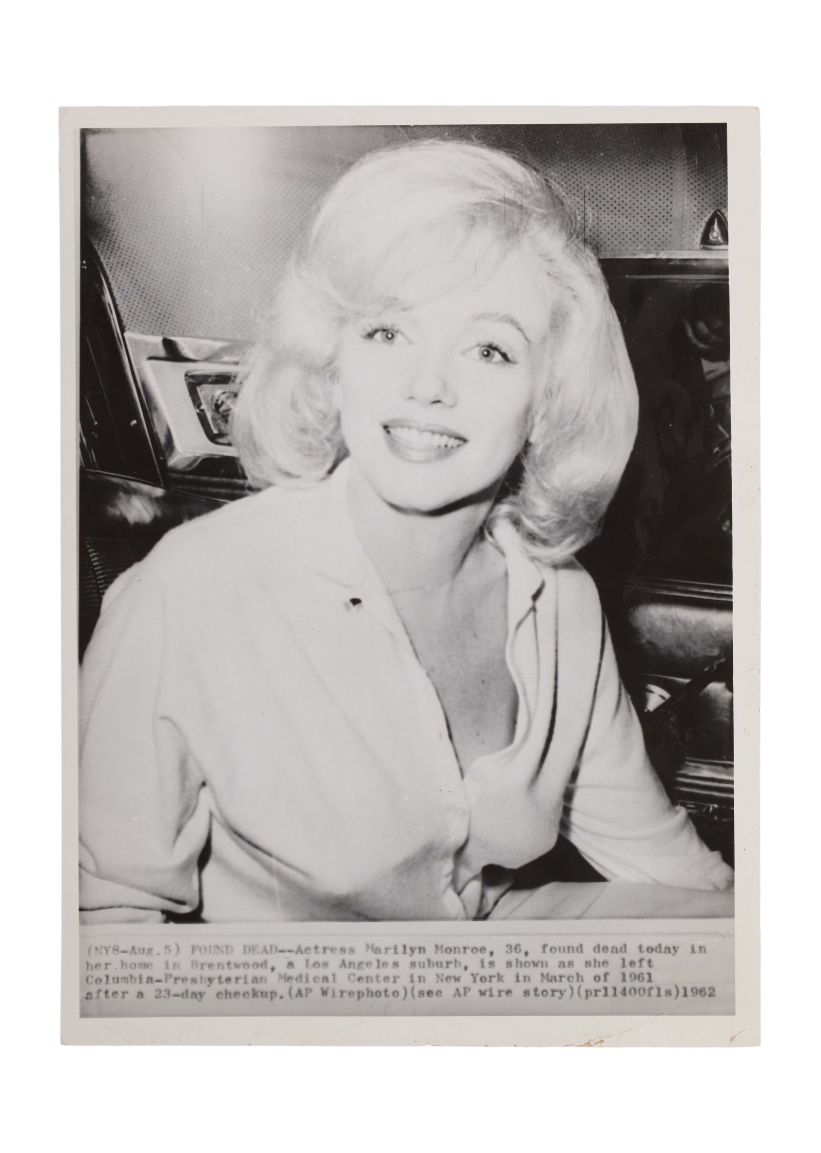 Marilyn Monroe | 1961/1962 Black and White Wire Photograph: A 1962 later print; glossy finish, depicting the star in March 1961 leaving a NYC hospital; verso with blue ink credit stamp reading in part "Associated Press / Wirephoto" and a date stamp of "Aug 23 